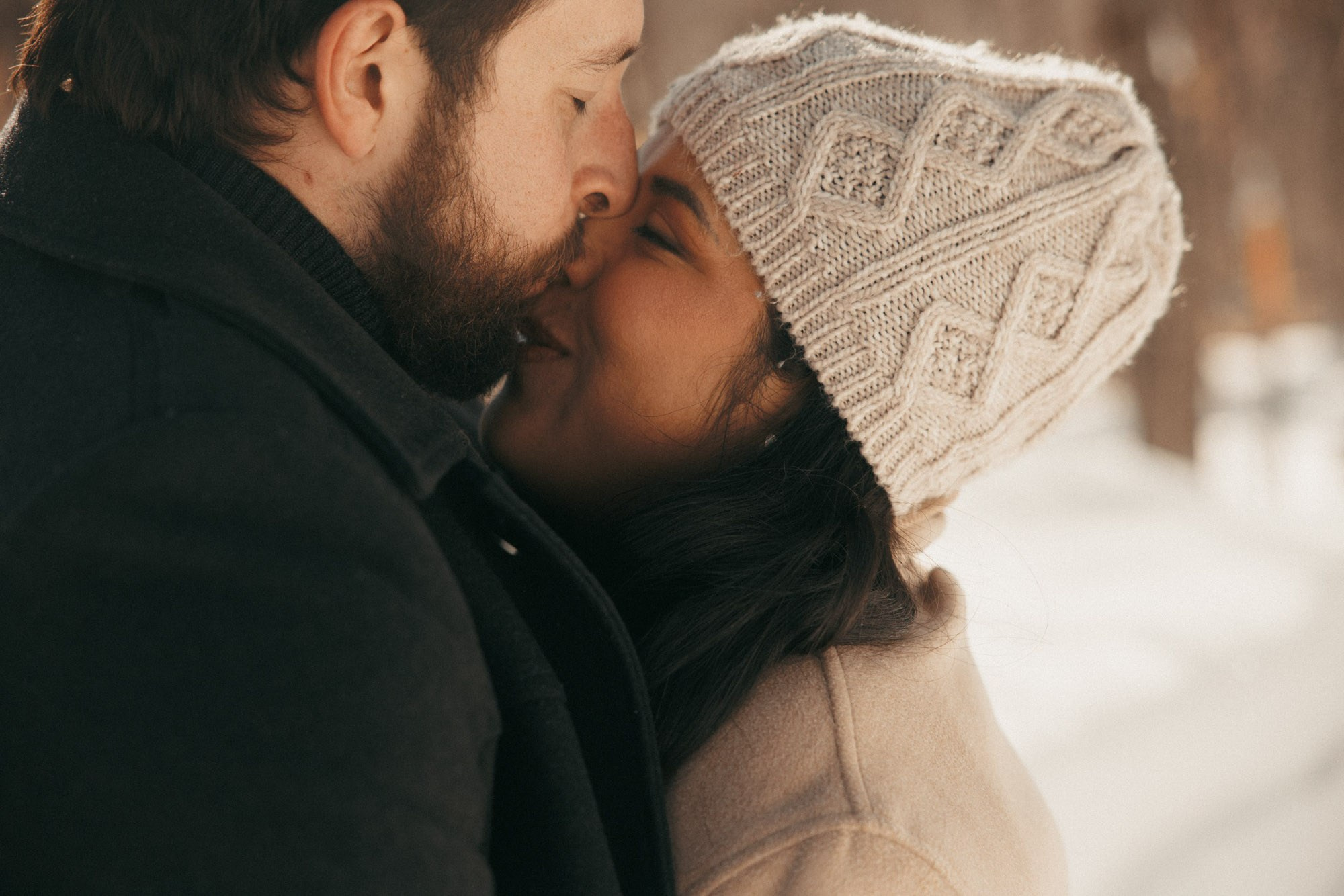 Expecting couple kissing during a snowy maternity session in Montreal
