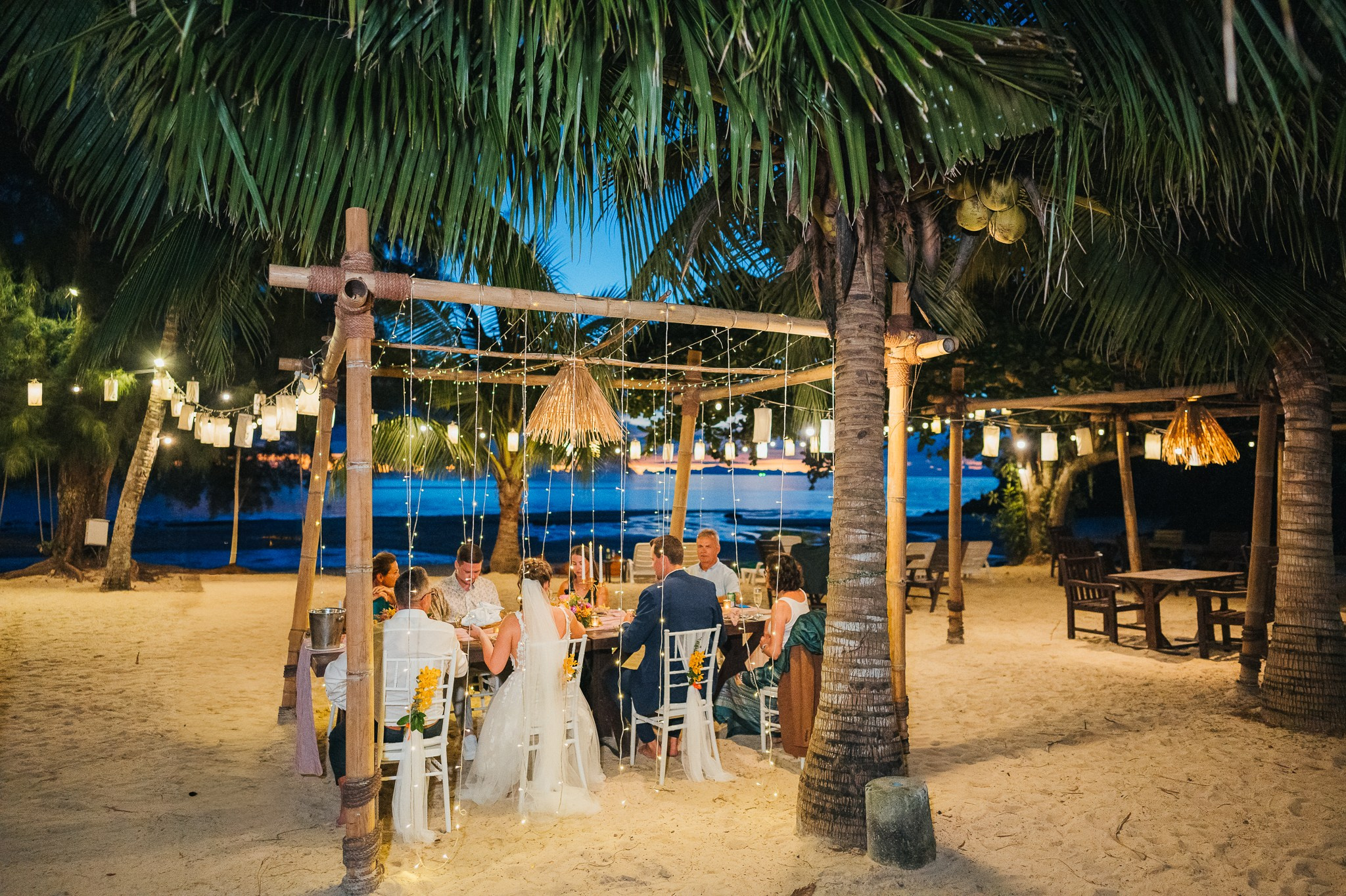 Destination beach wedding in Koh Samui, Thailand with the couple, family members and friends enjoying a tropical wedding ceremony by the sea