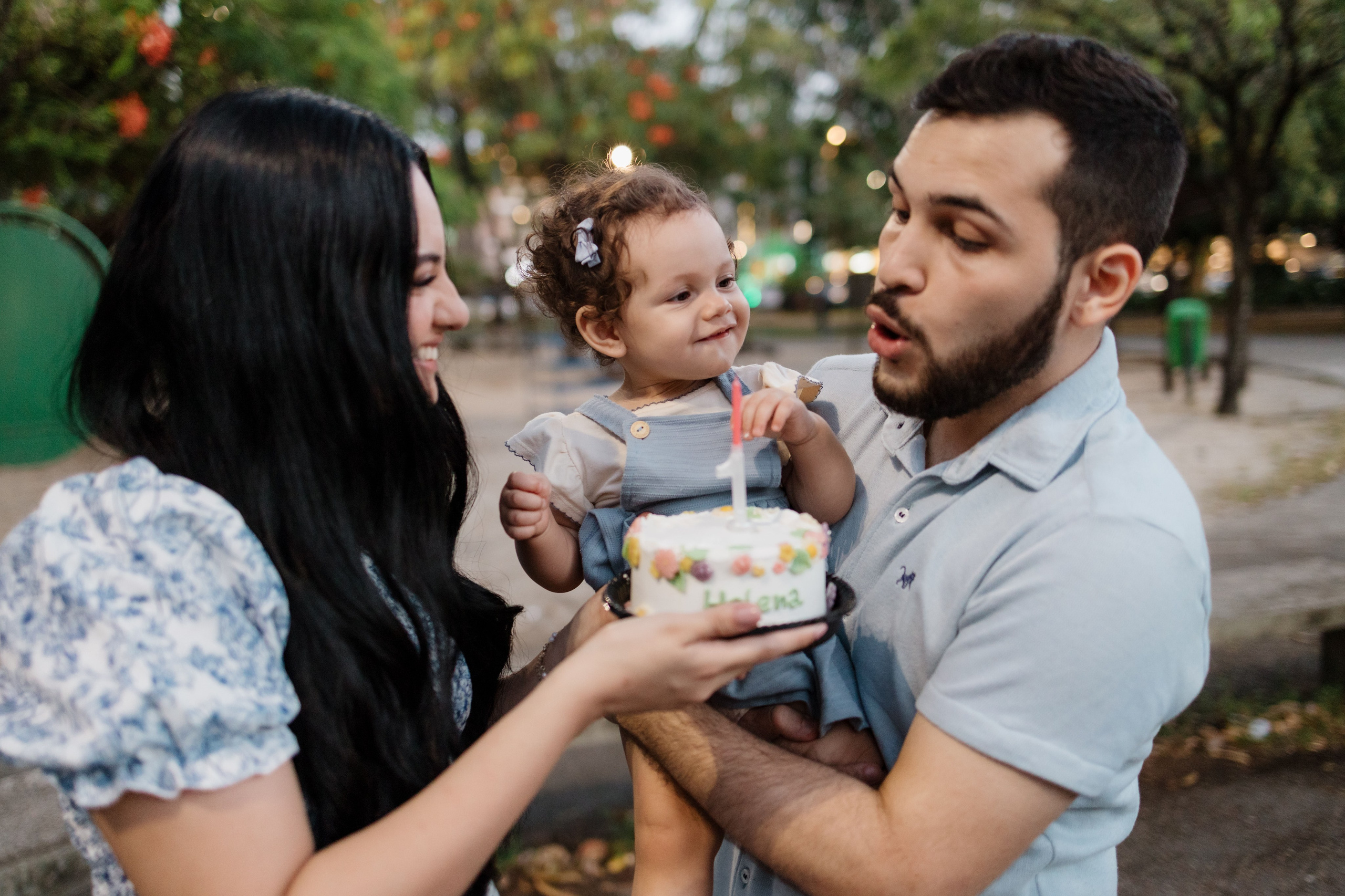 Família cantando parabéns de 1 ano em ensaio no parque