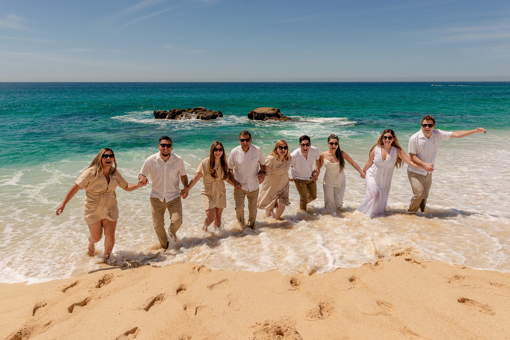 Beach family session in San Jose del Cabo – large family running from ocean waves, fun and candid destination photography