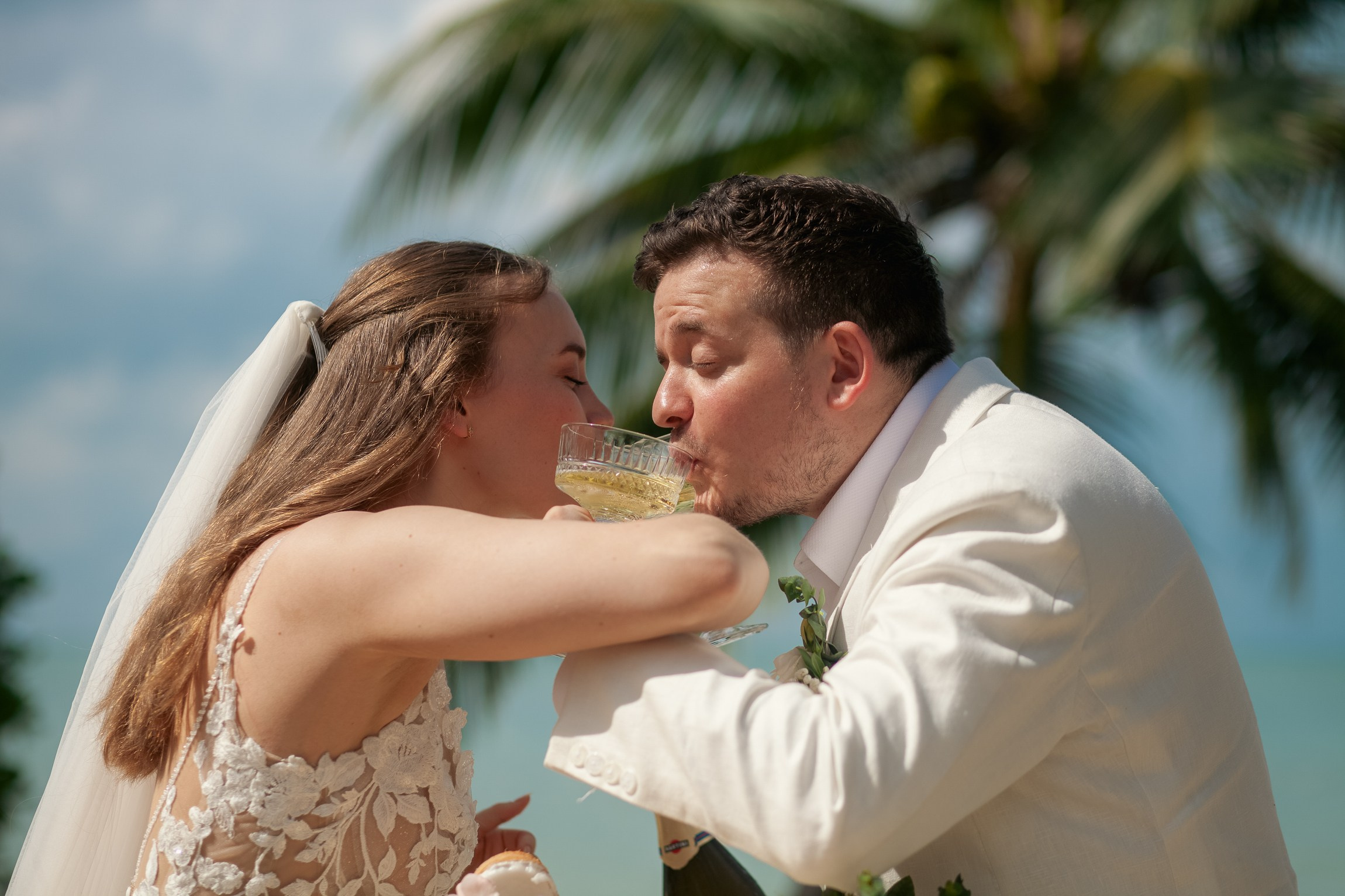 Romantic destination wedding on Koh Samui beach with tropical flowers, ocean views and happy newlyweds