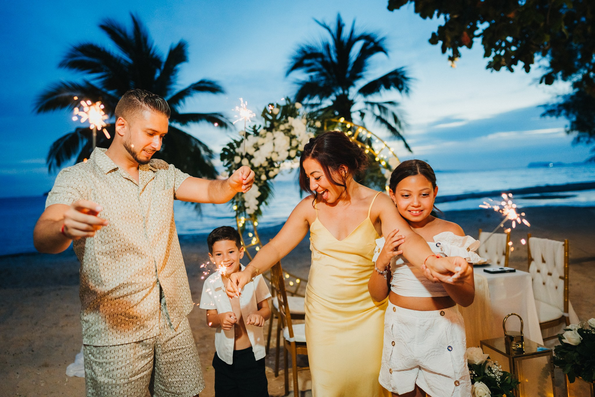 Intimate family wedding on the beach in Koh Samui, Thailand with the couple and their children enjoying the ceremony together