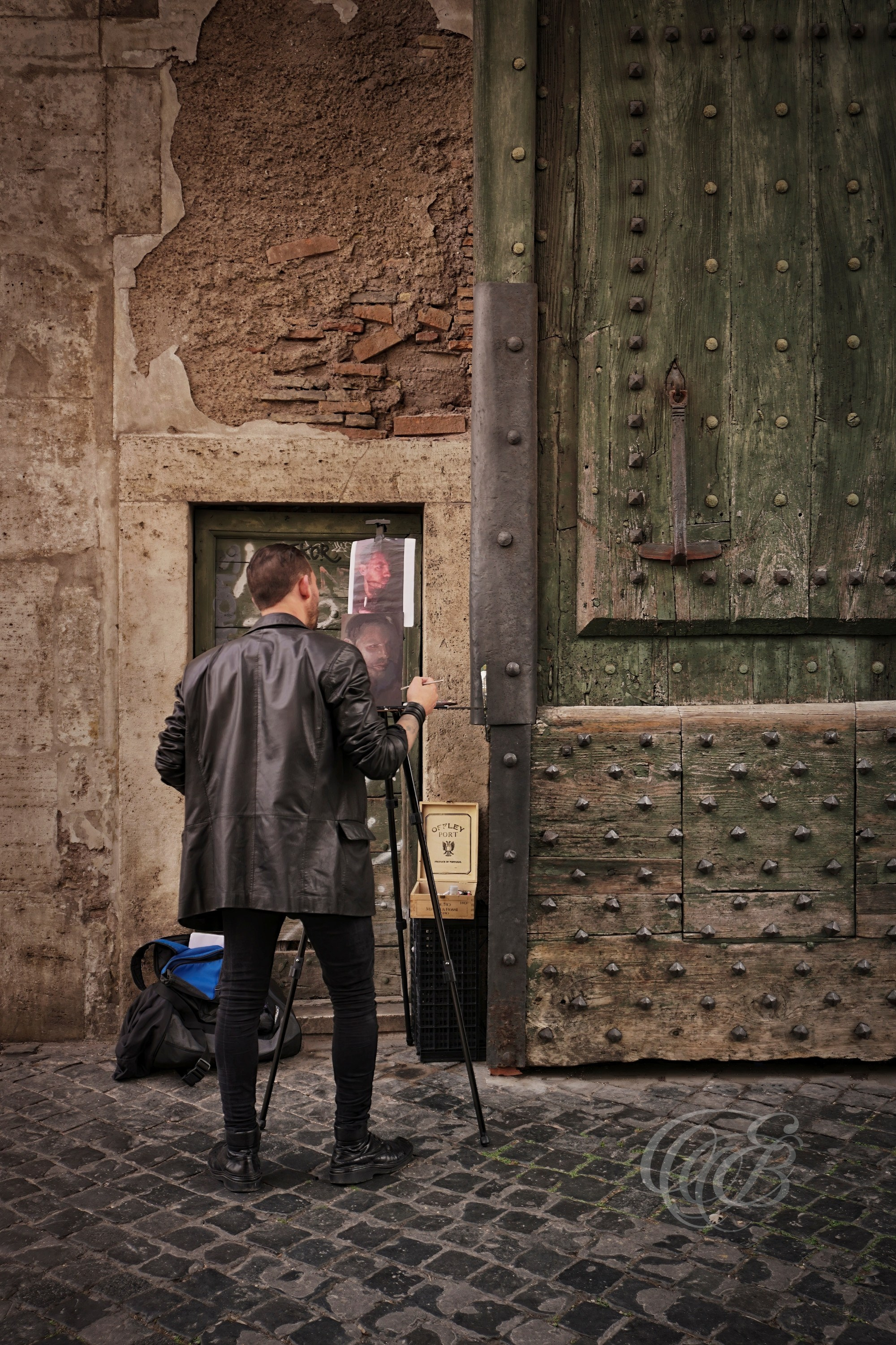 Street Photography — Rome, Italy — Roman Artist at Work — Artist painting near the monumental entrance of Piazza del Popolo, reflecting Rome’s enduring artistic tradition and the creative life that continues throughout the city’s historic public spaces — Eduardo Bartoli Photography.