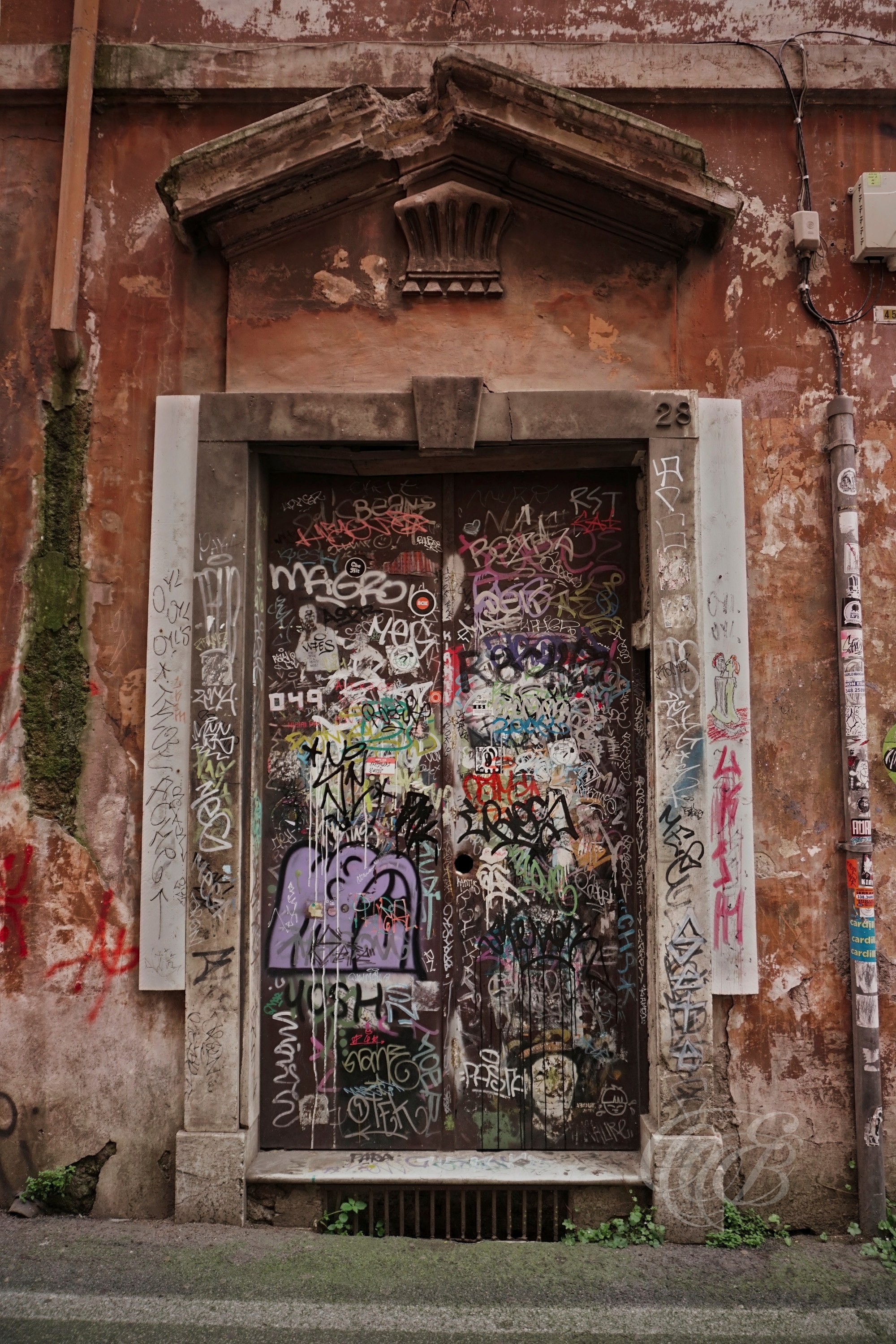 Street Photography — Rome, Italy — Door Covered in Graffiti — Graffiti-covered doorway in Rome, reflecting contemporary street expression, layered urban textures, and the evolving character of the city’s historic streets — Eduardo Bartoli Photography.