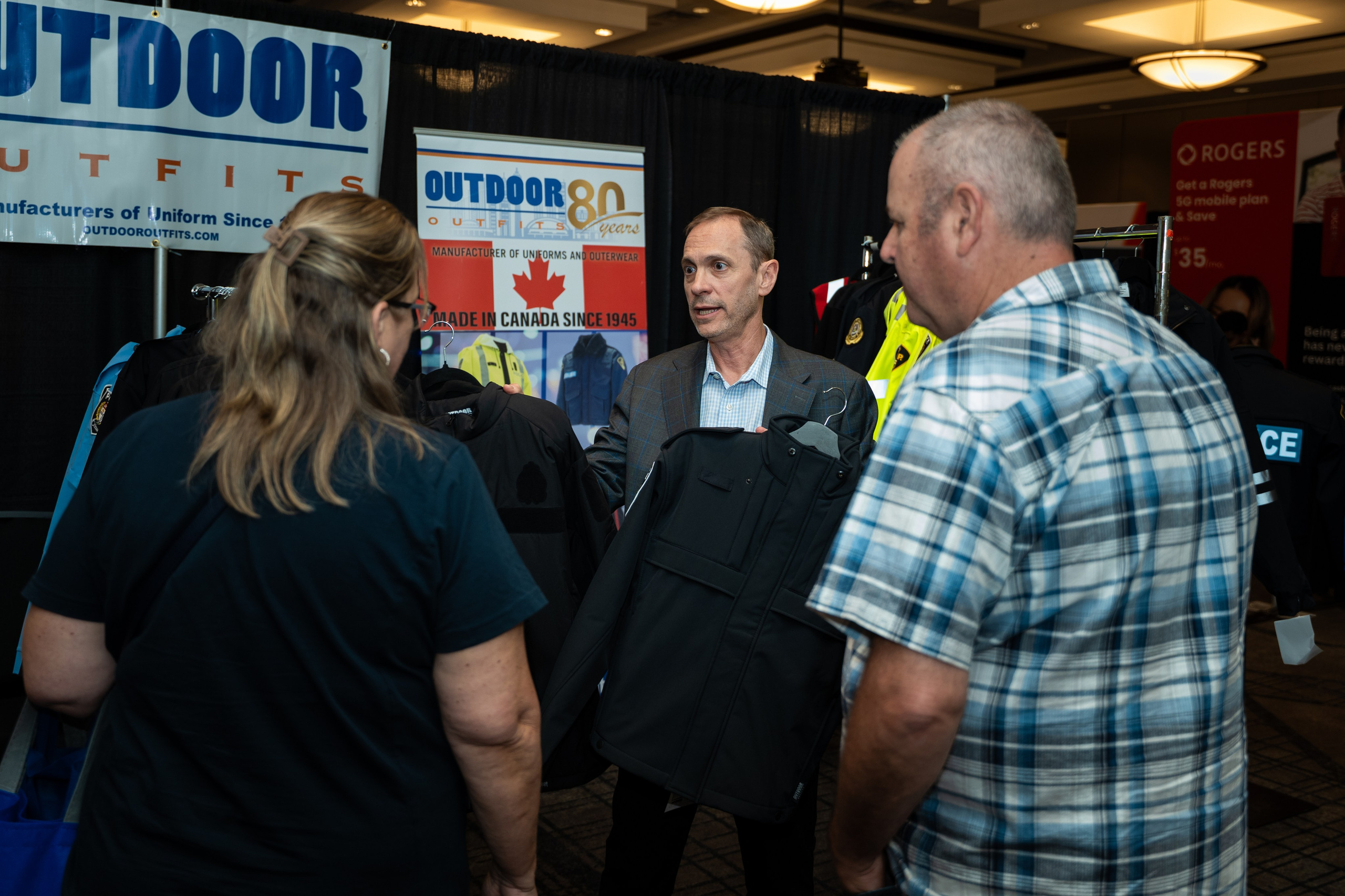 Attendee in plaid shirt speaking with exhibitor, Blueline Expo
