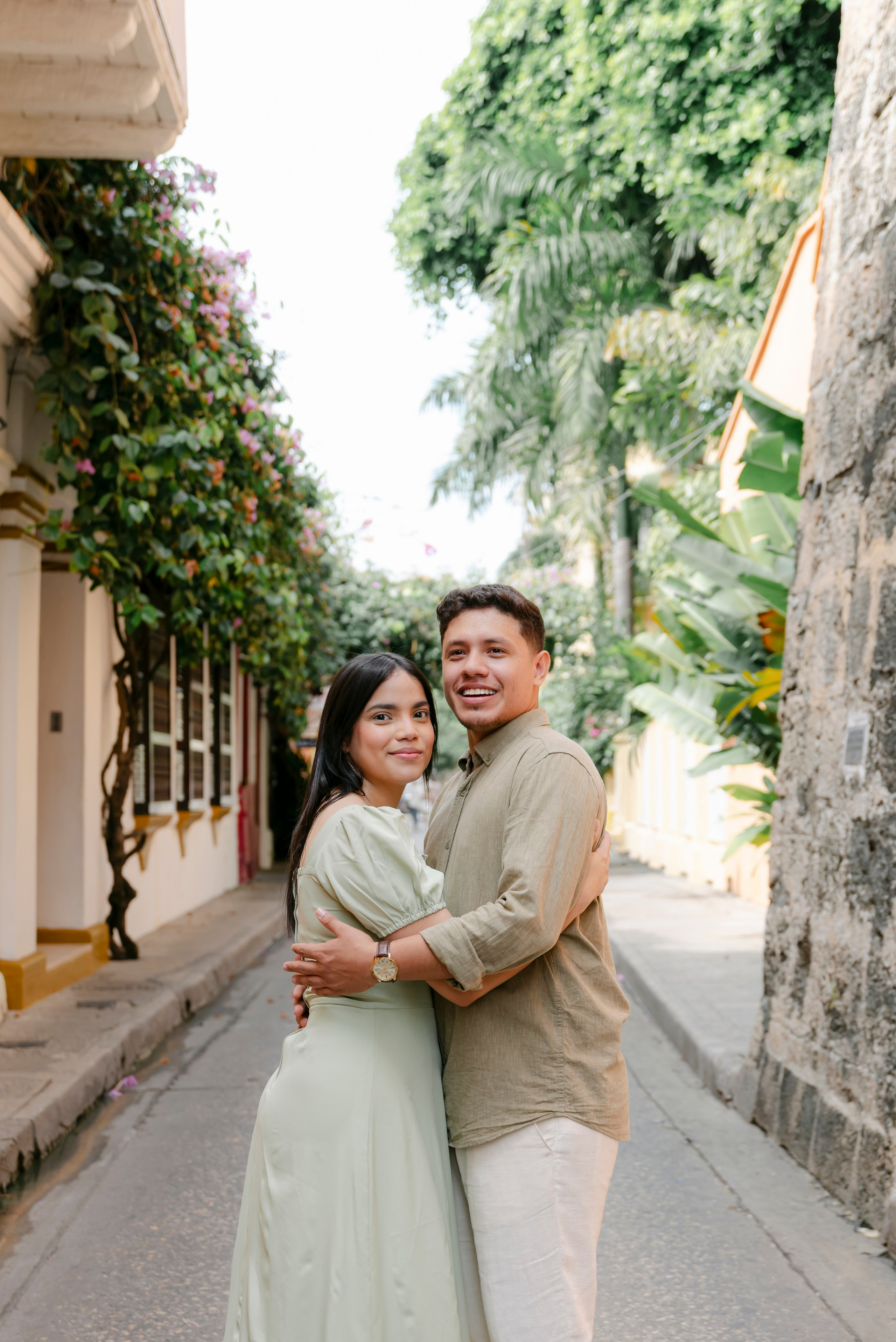 Pareja abrazada mirando la camara en hermosa calle colonial de cartagena