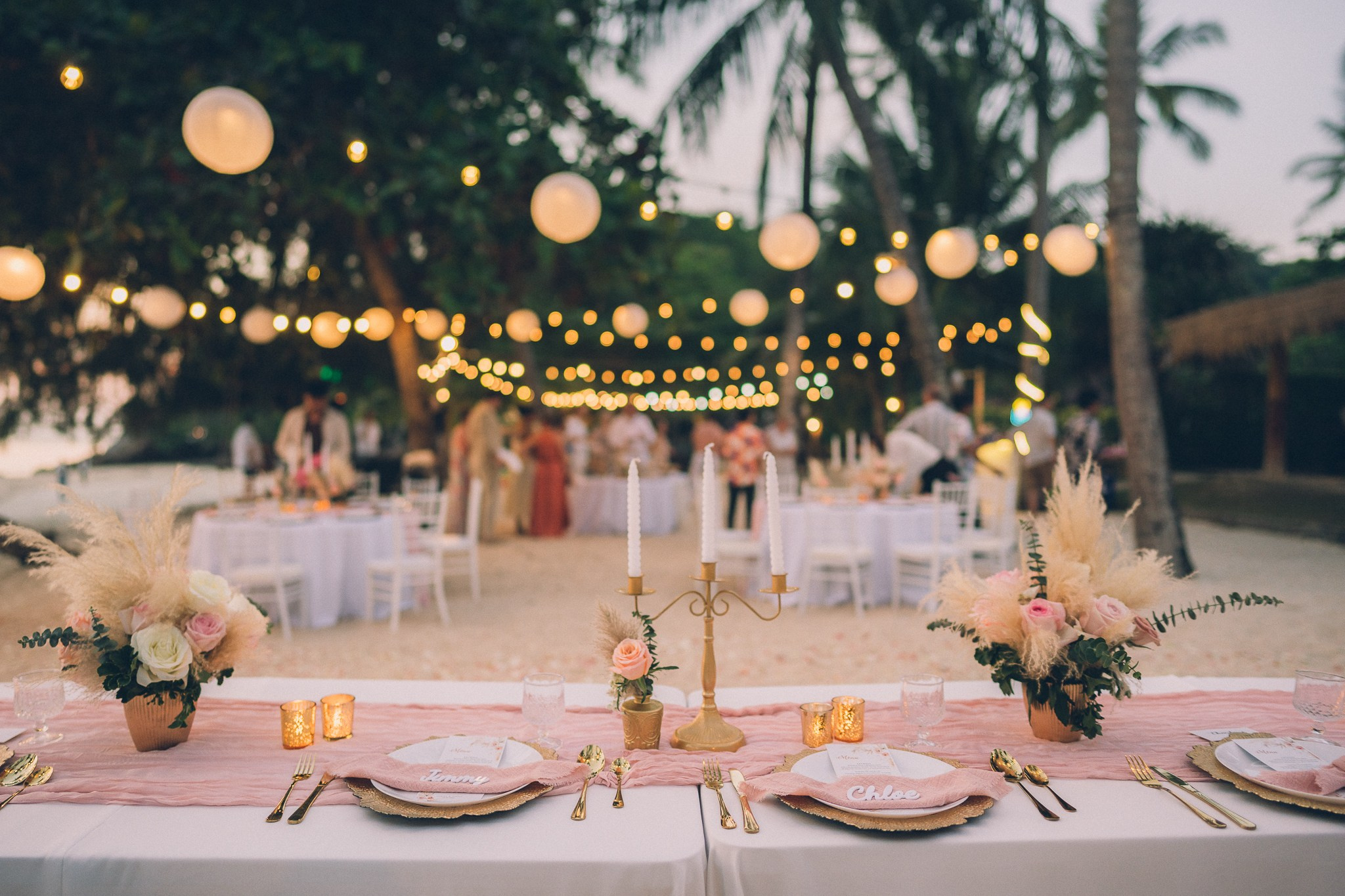 Wedding celebration with guests on a tropical sunset beach in Koh Samui