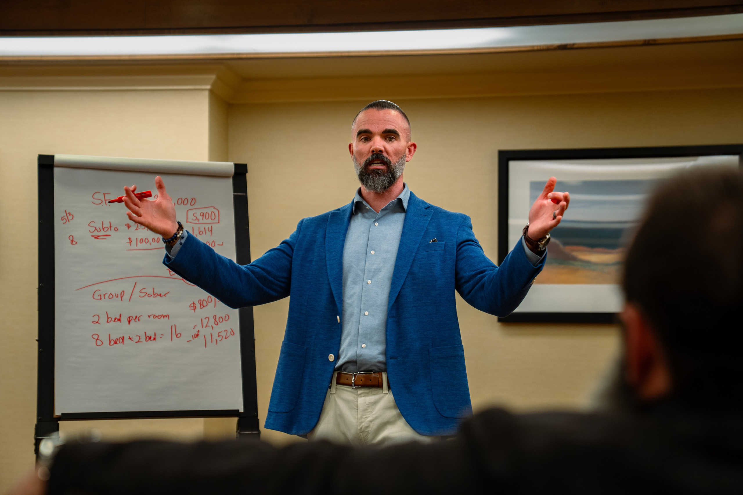Matt Poechman speaking with hands raised during presentation