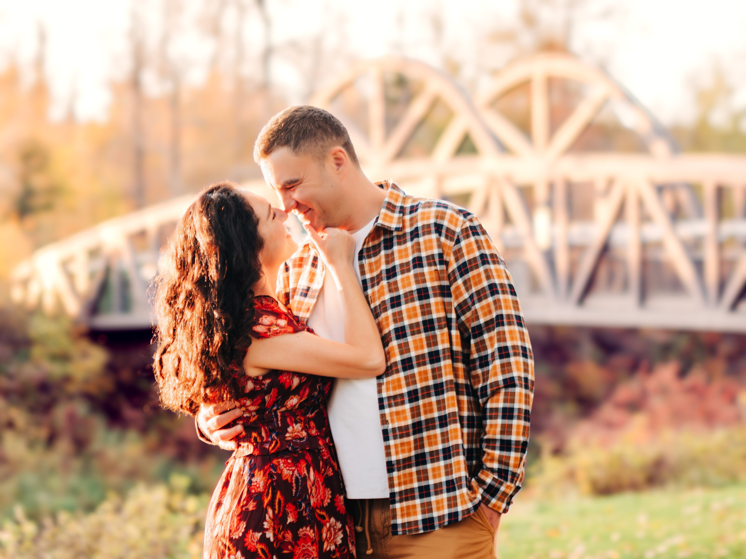 Romantic couples photography by Dimitri Studio. Couple embracing near a wooden bridge at sunset in Spruce Grove. Book at dimitristudio.com