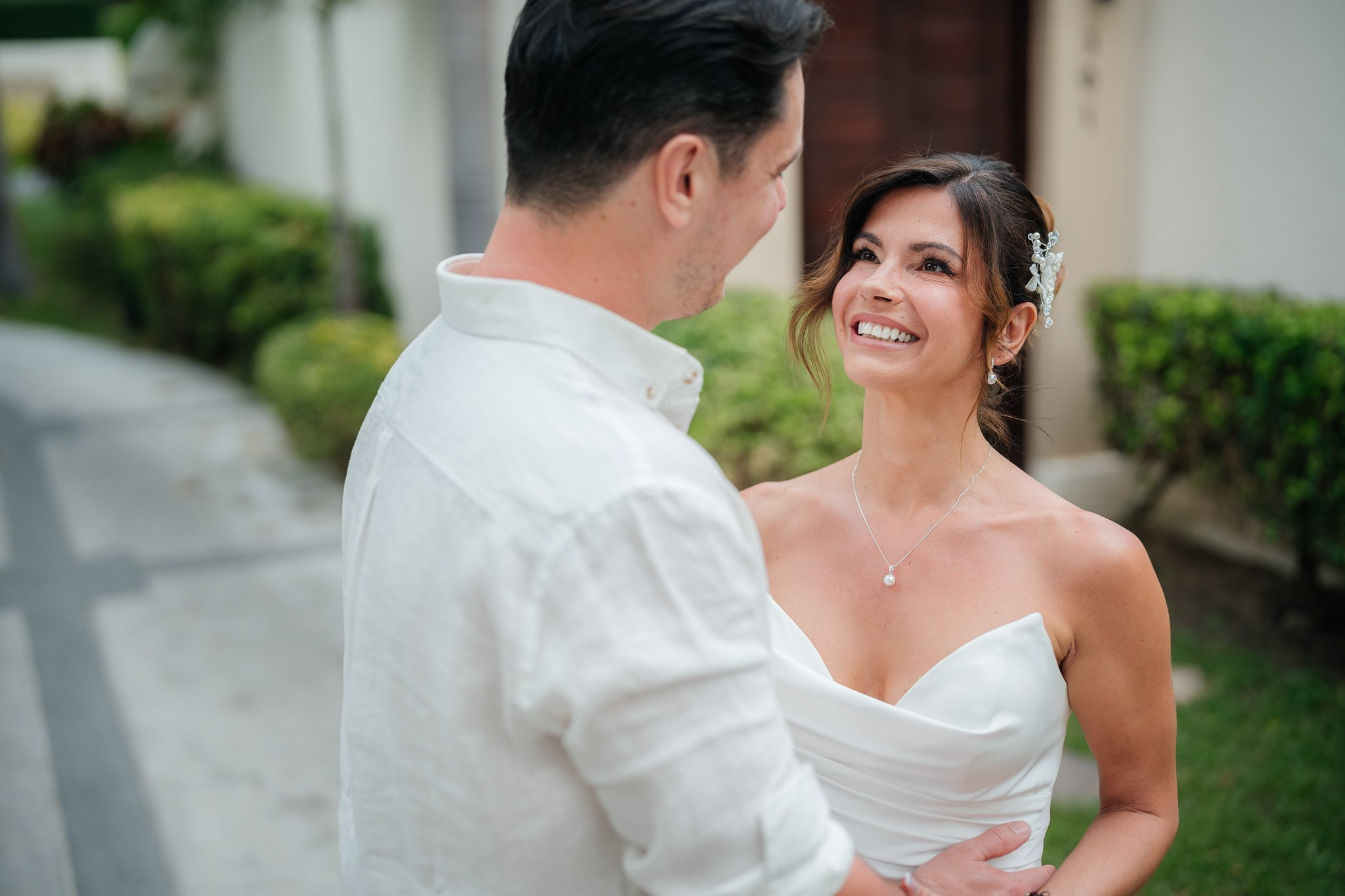 Bride and groom celebrating a beach wedding with their children in Koh Samui, Thailand, surrounded by tropical scenery and ocean views