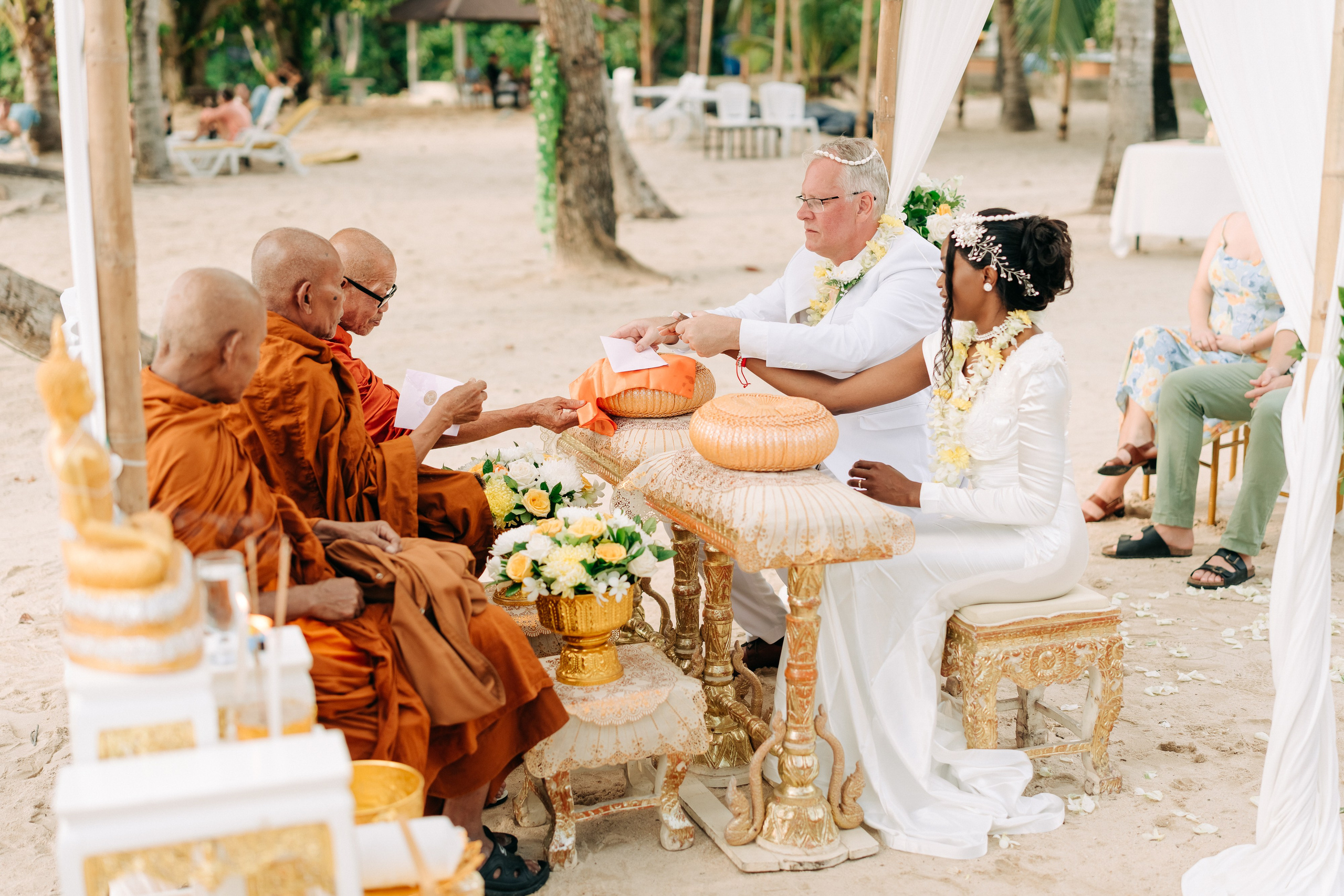Couple receiving a traditional Buddhist wedding blessing from Thai monks in Koh Samui