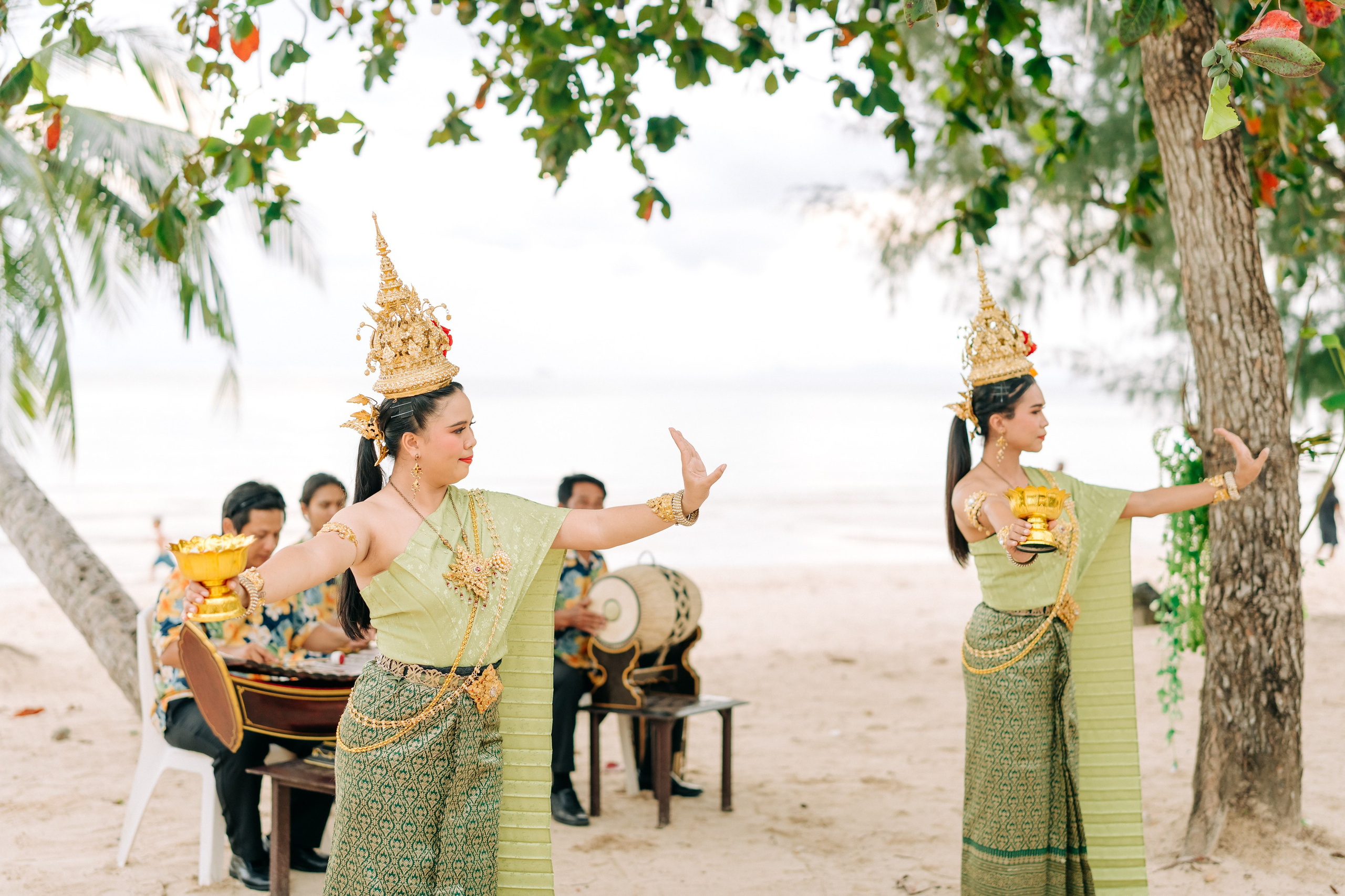 Couple taking part in a traditional Buddhist wedding ceremony on a tropical beach in Koh Samui, Thailand, with monks, flowers, and ocean views.