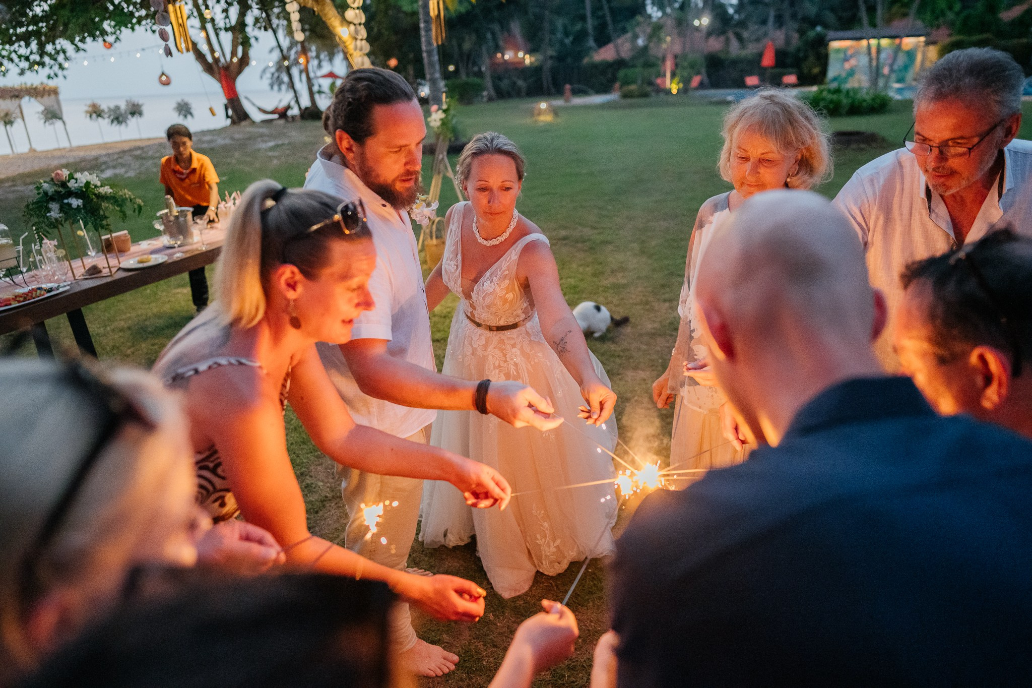 Bride and groom celebrating a beautiful beach wedding in Koh Samui, Thailand, surrounded by friends and family with tropical ocean views
