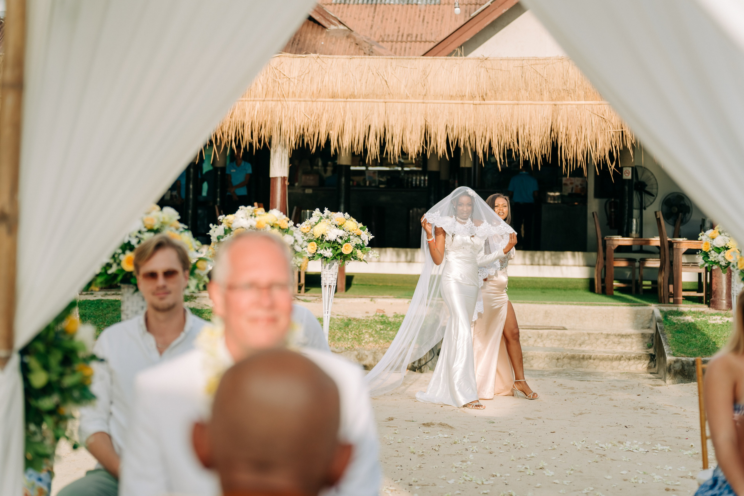 Newlywed couple celebrating a Buddhist wedding ceremony on a beautiful beach in Koh Samui, Thailand.
