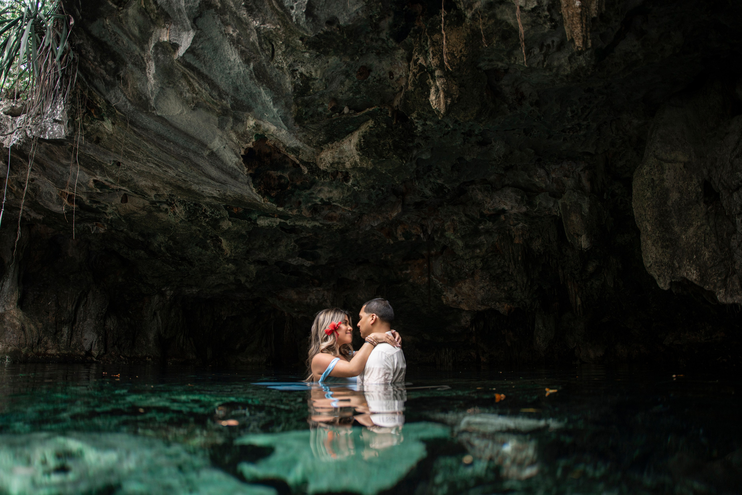 Peaceful and stylish pregnancy photo in a cave with crystal-clear water