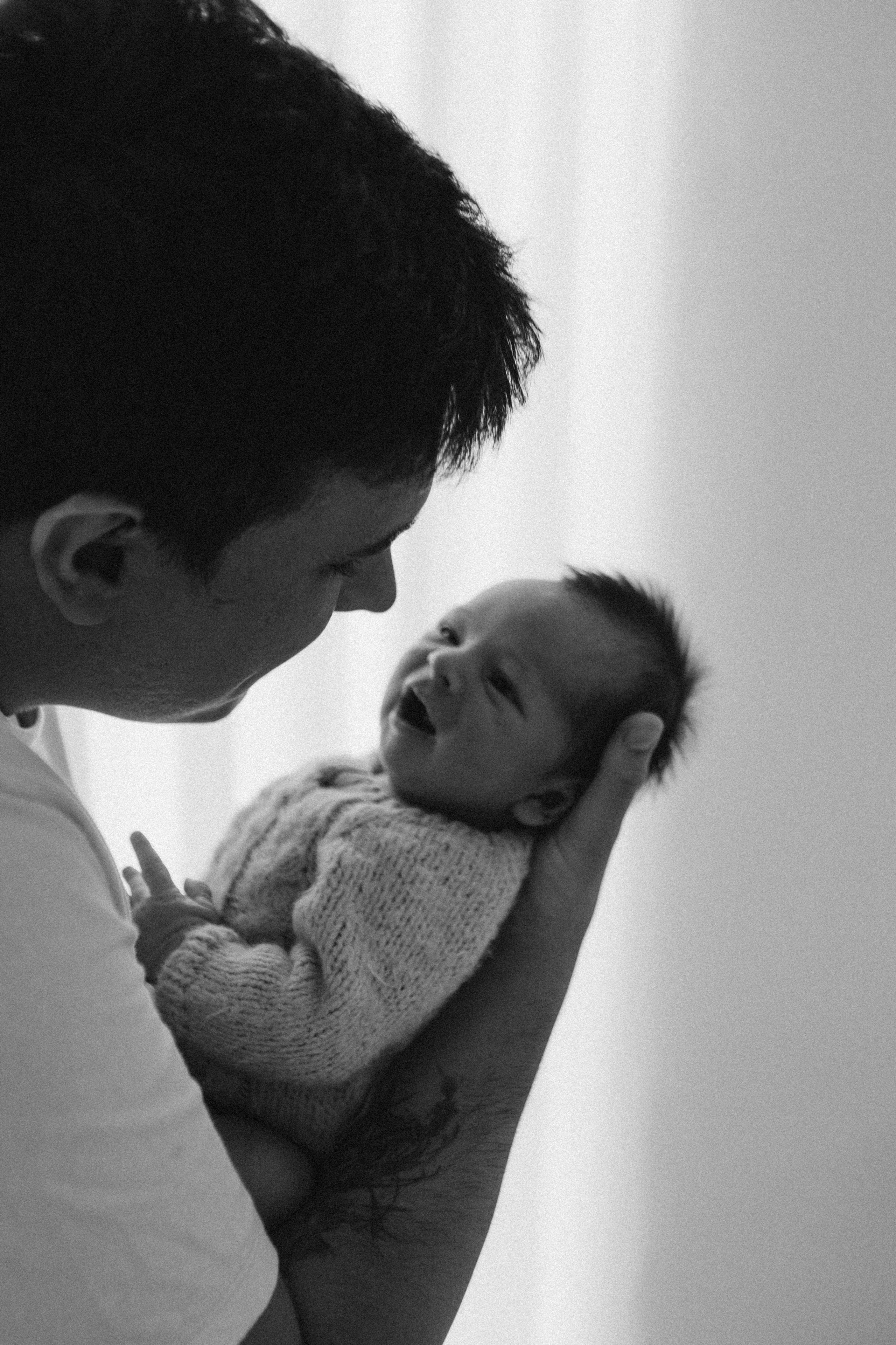 pai com bebê no colo em ensaio newborn com luz natural em Sorocaba
