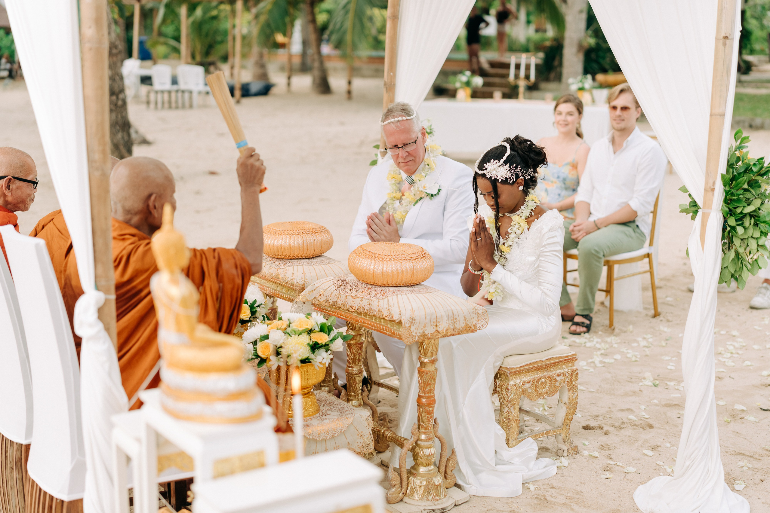 Couple receiving a traditional Buddhist wedding blessing from Thai monks in Koh Samui