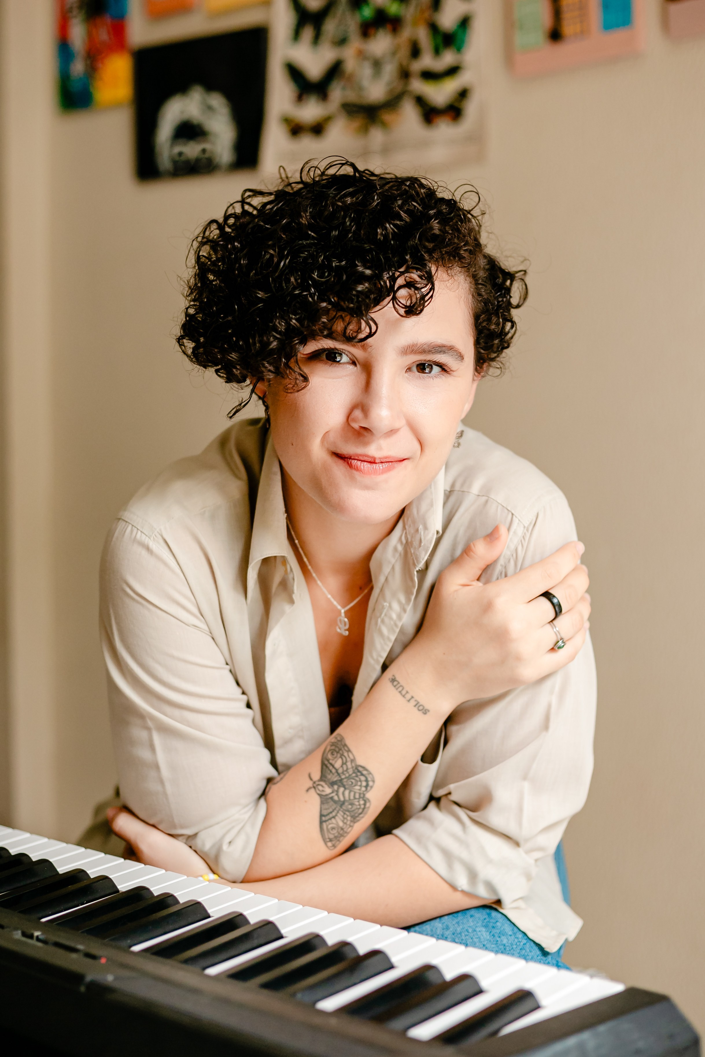 Mulher olhando pra câmera com piano.