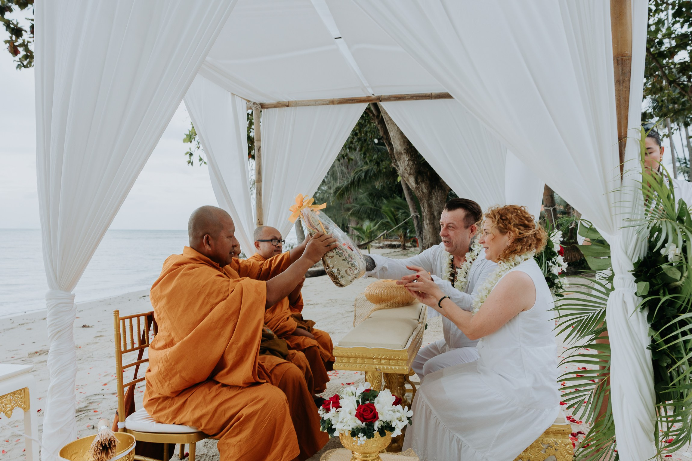 Couple with guests celebrating a spiritual Buddhist wedding ceremony on Koh Samui