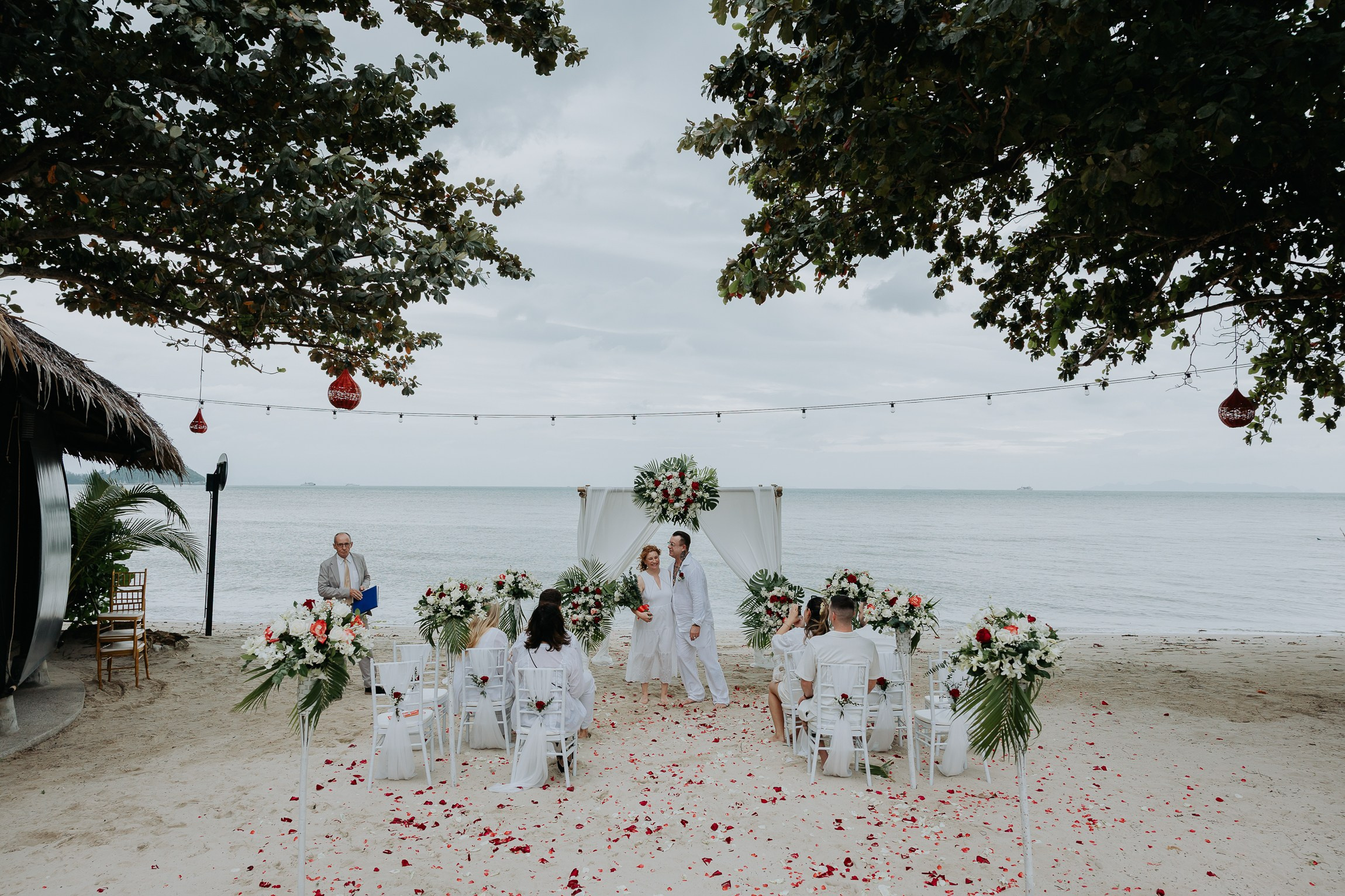 Bride and groom participating in a sacred Buddhist wedding blessing in Thailand
