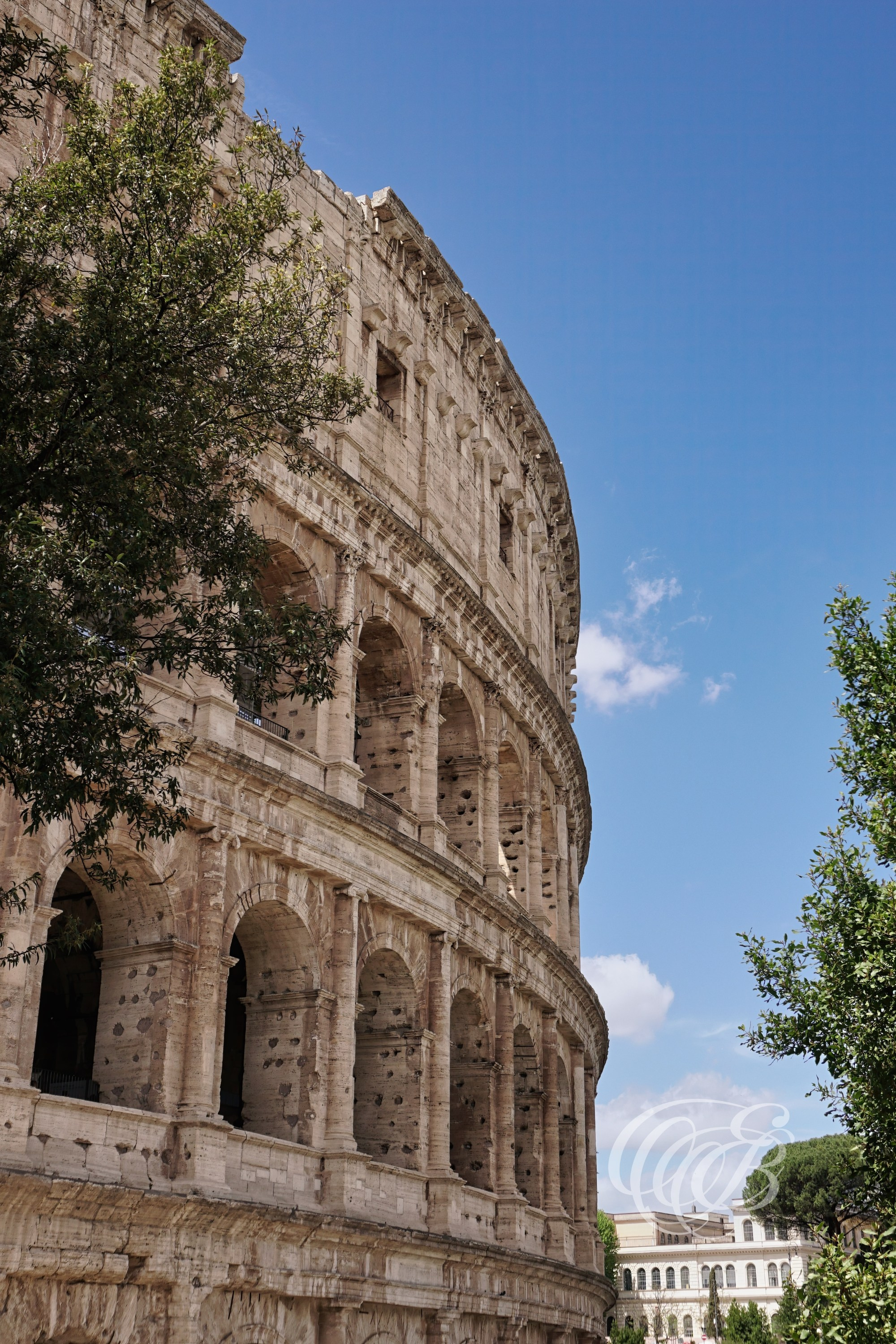 ITALY TRAVEL PHOTOGRAPHY – ITALY – ROME — Exterior View of the Colosseum on a Sunny Day — Colosseum exterior showing travertine stone arches and architectural rhythm in bright daylight, Rome, Italy — Eduardo Bartoli Photography.