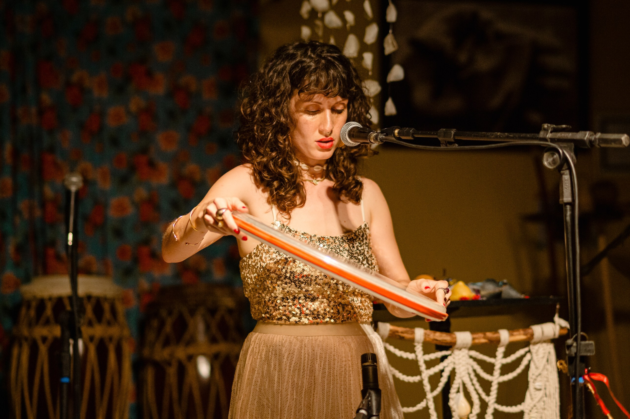 Fotógrafo de show em Balneário Camboriú; a cantora Joana Gaia utilizando instrumento de percussão no palco durante apresentação no bairro da Barra para a divulgação do álbum "Água Brasileira".
