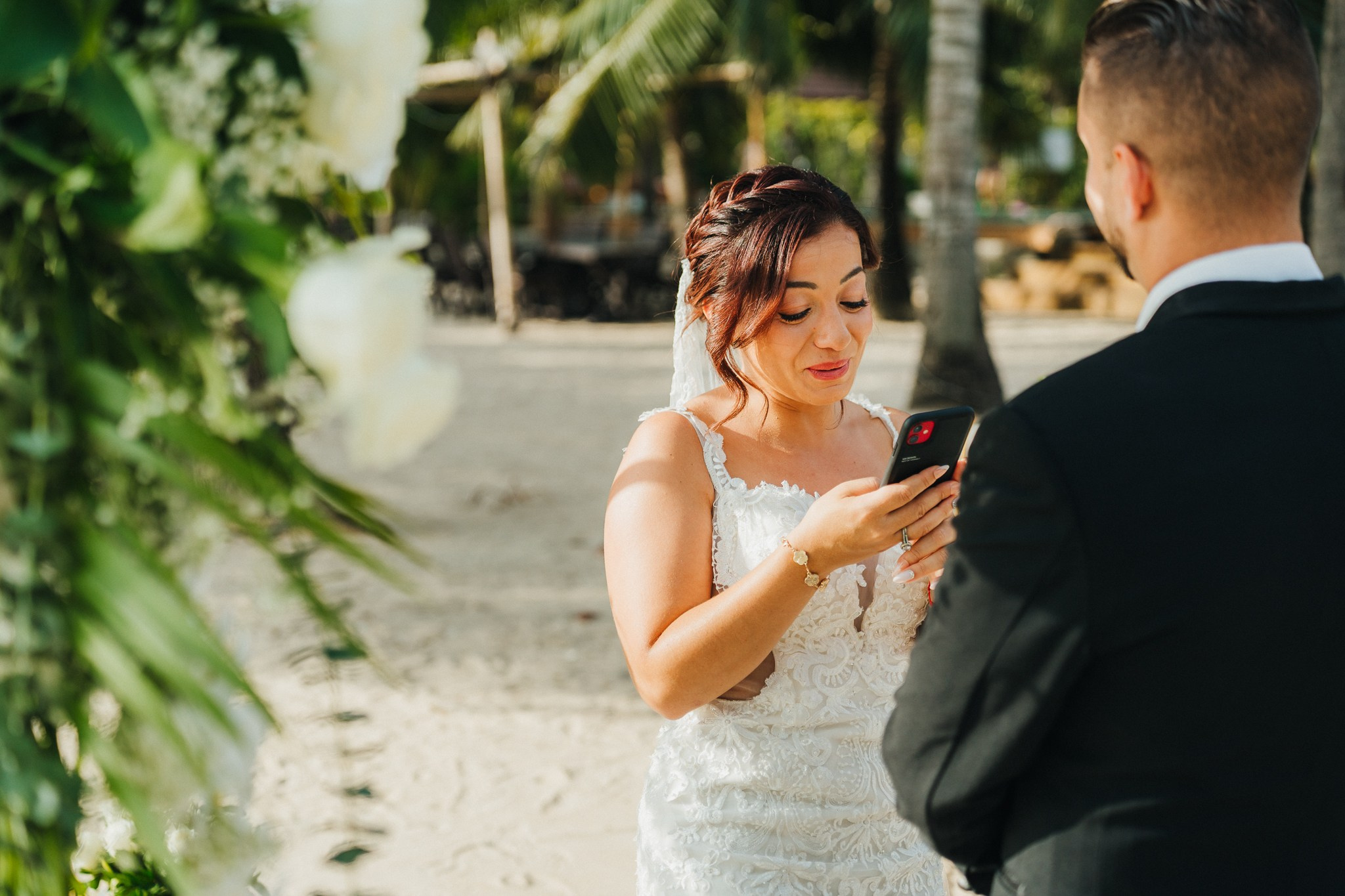 Bride and groom celebrating a beach wedding with their children in Koh Samui, Thailand, surrounded by tropical scenery and ocean views
