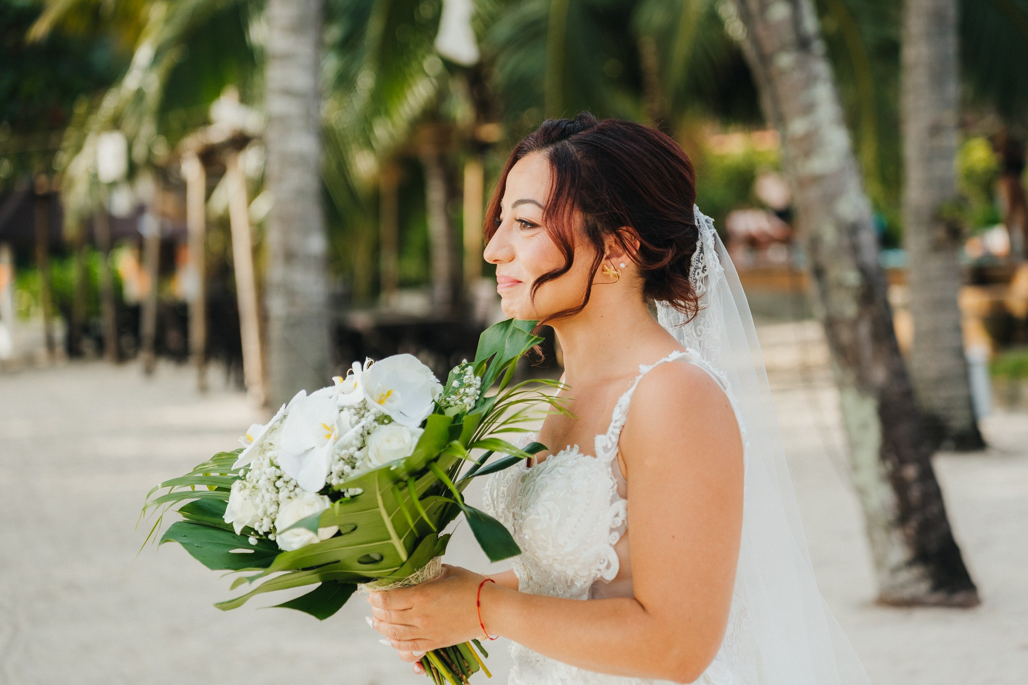 Bride and groom celebrating a beach wedding with their children in Koh Samui, Thailand, surrounded by tropical scenery and ocean views