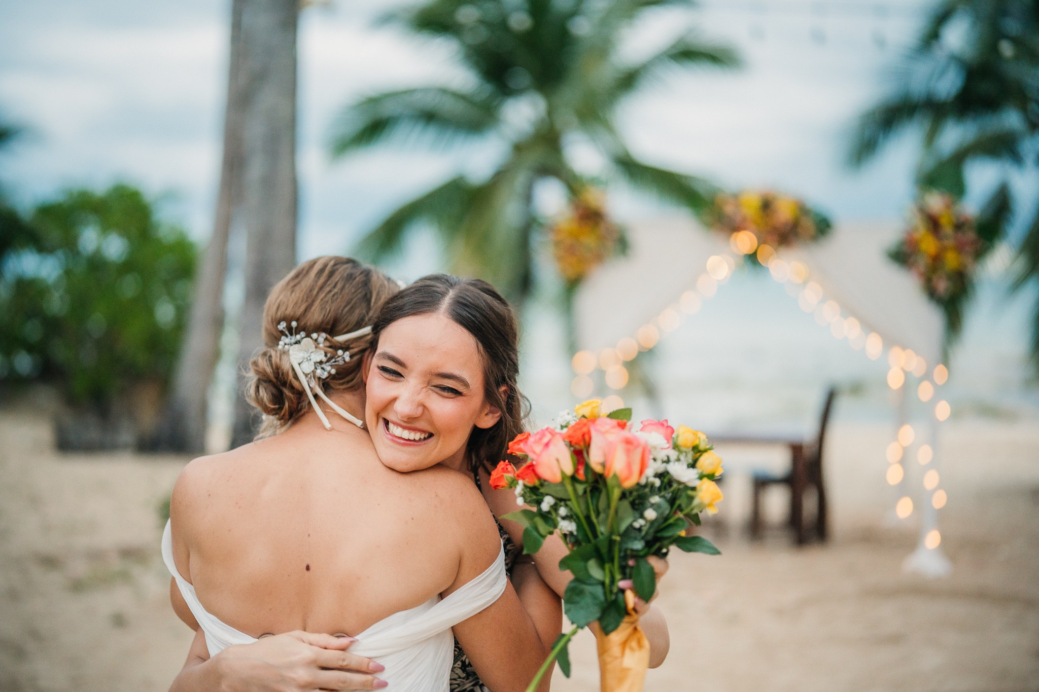 Couple taking part in a traditional Buddhist wedding ceremony on a tropical beach in Koh Samui, Thailand, with monks, flowers, and ocean views.