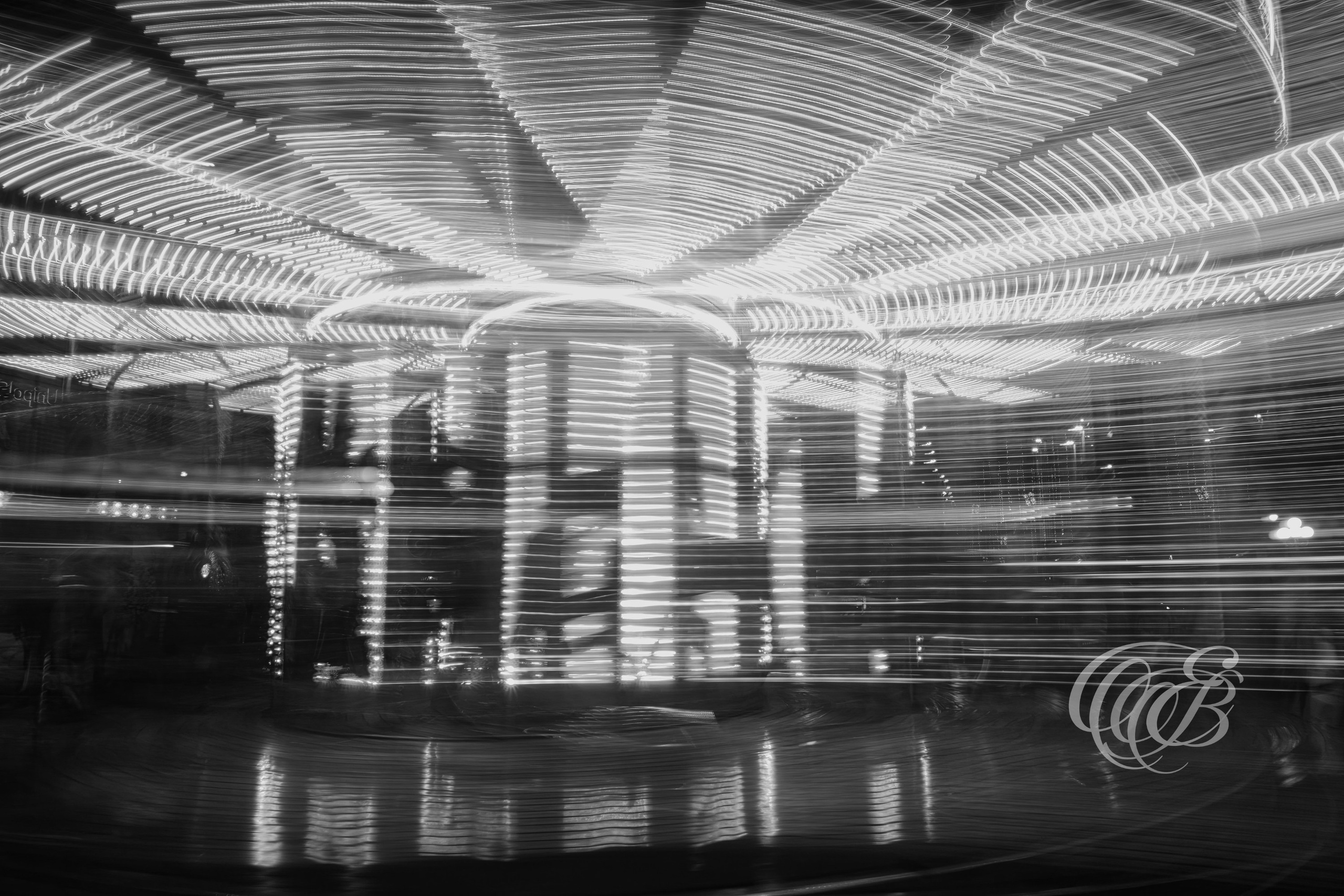 ITALY – FLORENCE — Carousel Long Exposure Abstract Light Motion Black and White — Long exposure photograph of carousel creating swirling light trails and motion blur in urban setting, abstract representation of movement and time, Florence, Italy — Eduardo Bartoli Photography.