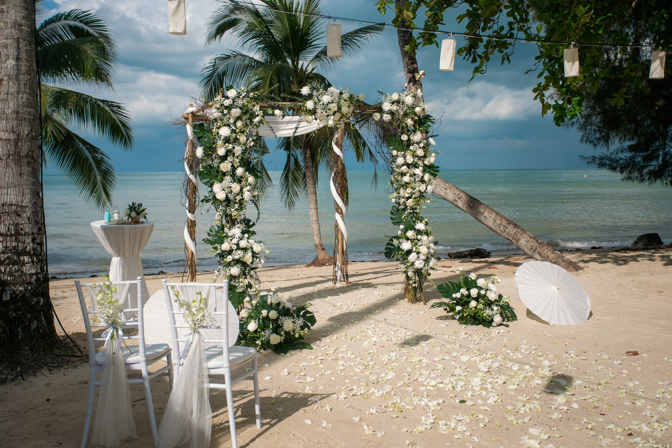 Romantic destination wedding on Koh Samui beach with tropical flowers, ocean views and happy newlyweds