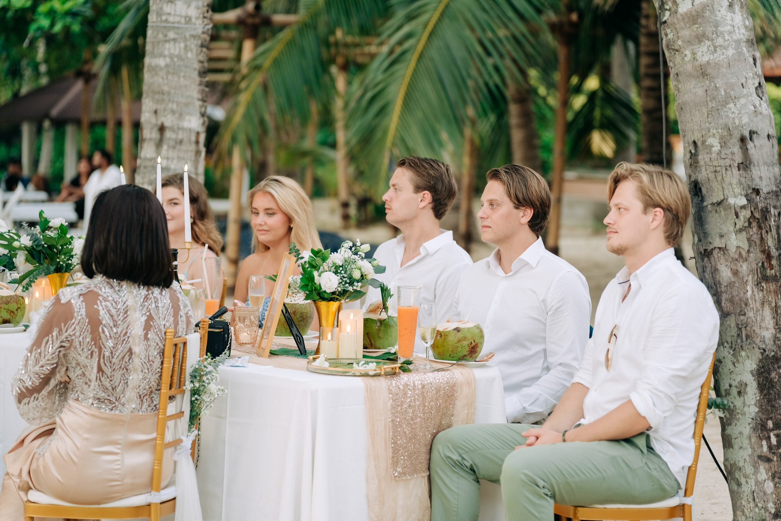 Newlywed couple celebrating a Buddhist wedding ceremony on a beautiful beach in Koh Samui, Thailand.