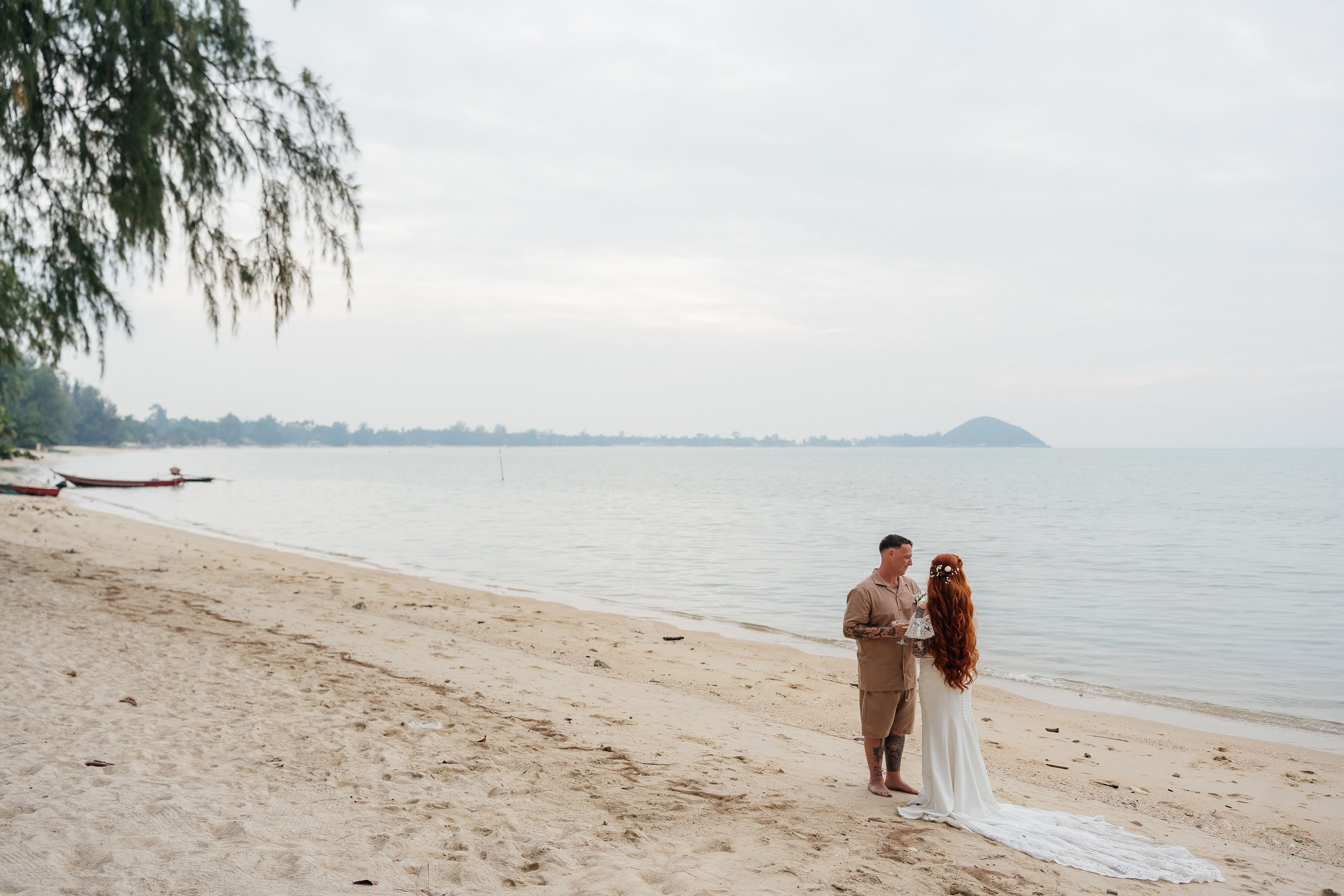 Romantic destination wedding on Koh Samui beach with tropical flowers, ocean views and happy newlyweds
