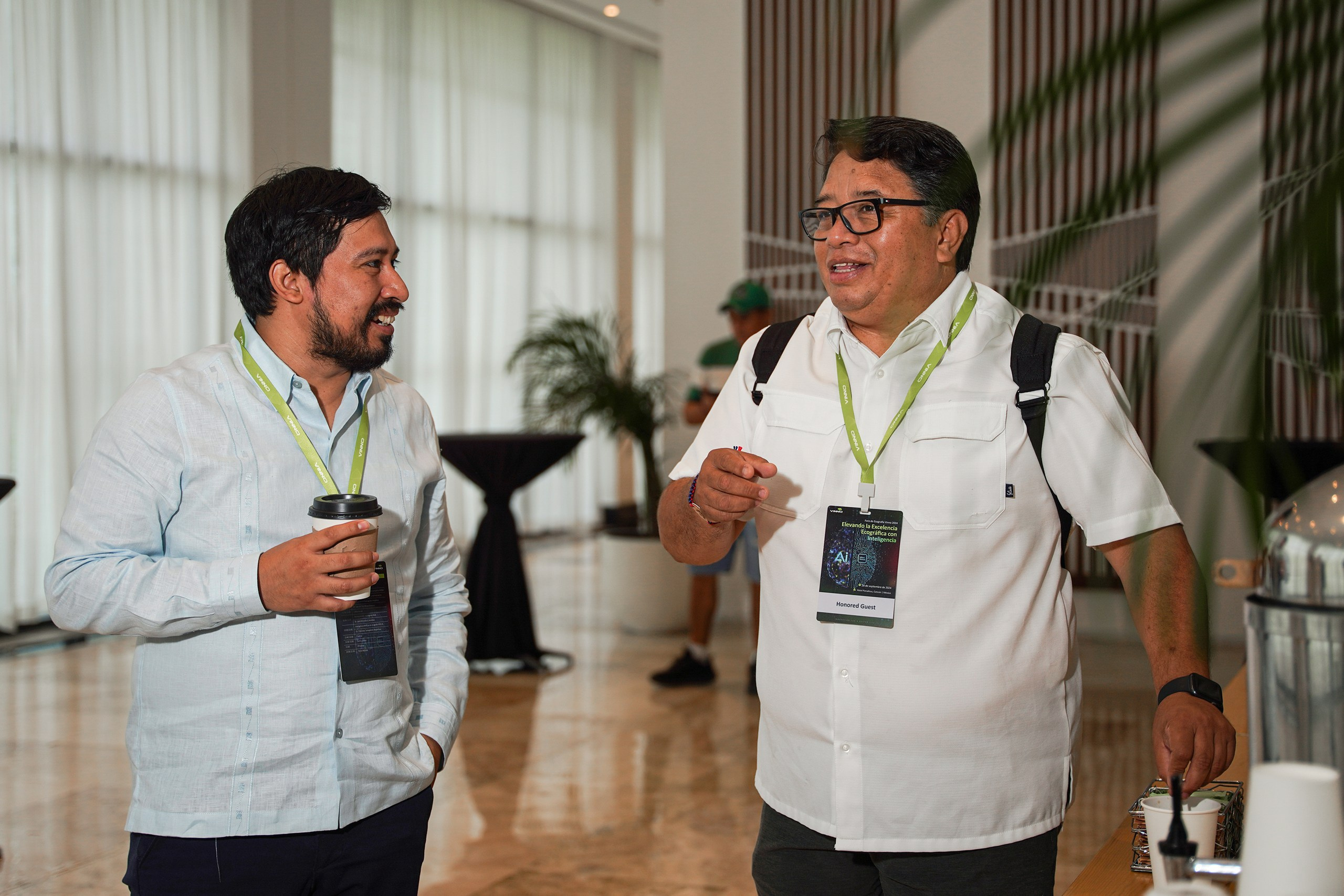 Professionals engaged in conversation at event reception.