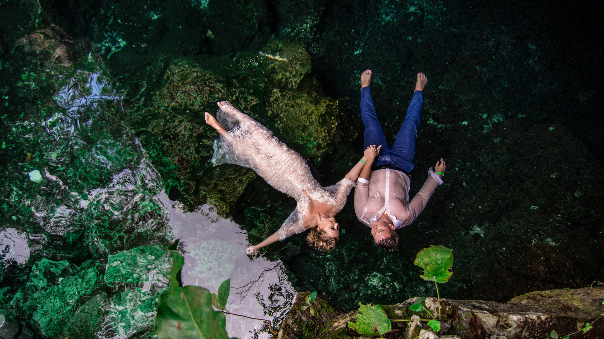 Just married couple posing in magical water cave