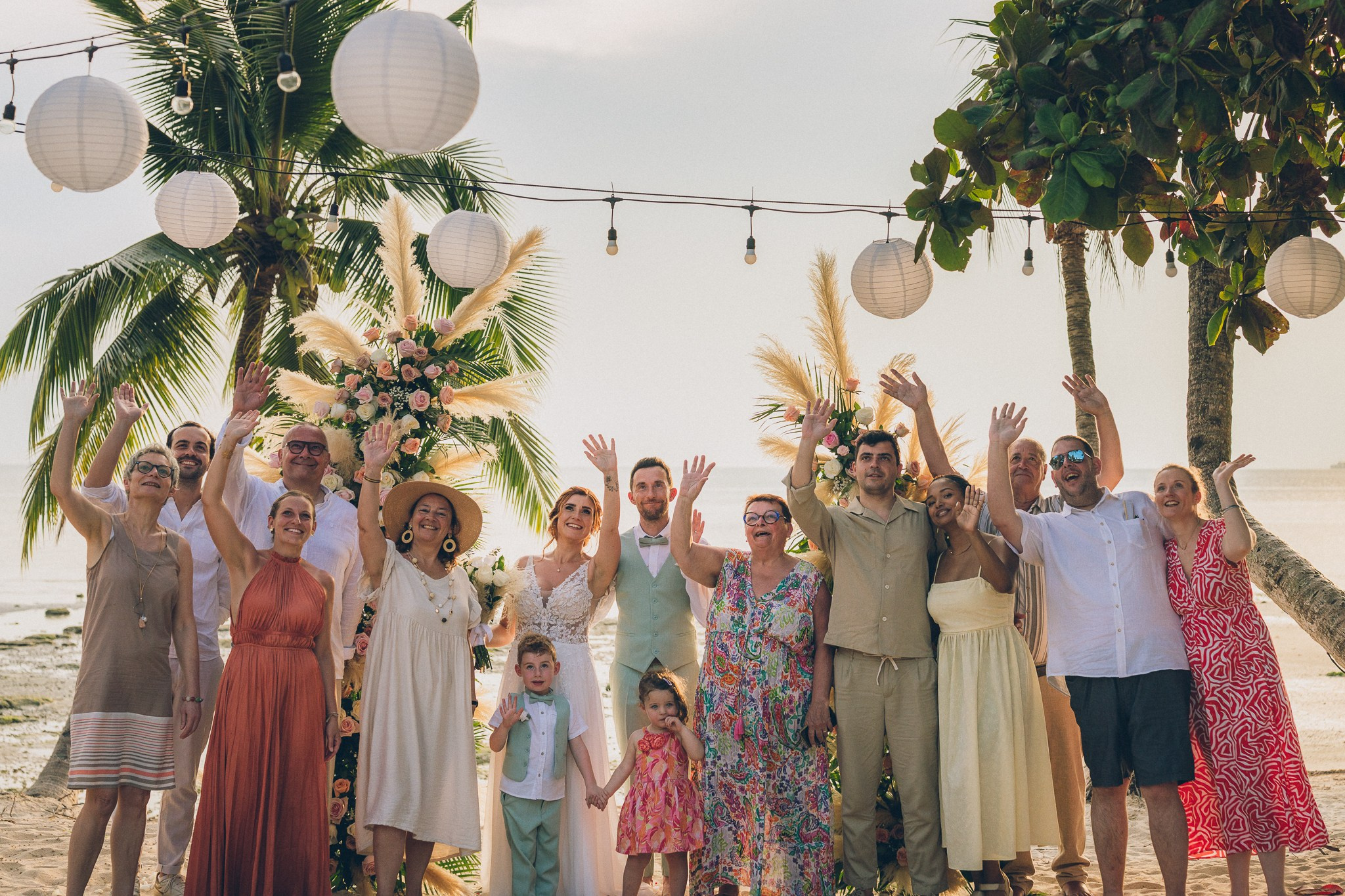 Wedding celebration with guests on a tropical sunset beach in Koh Samui