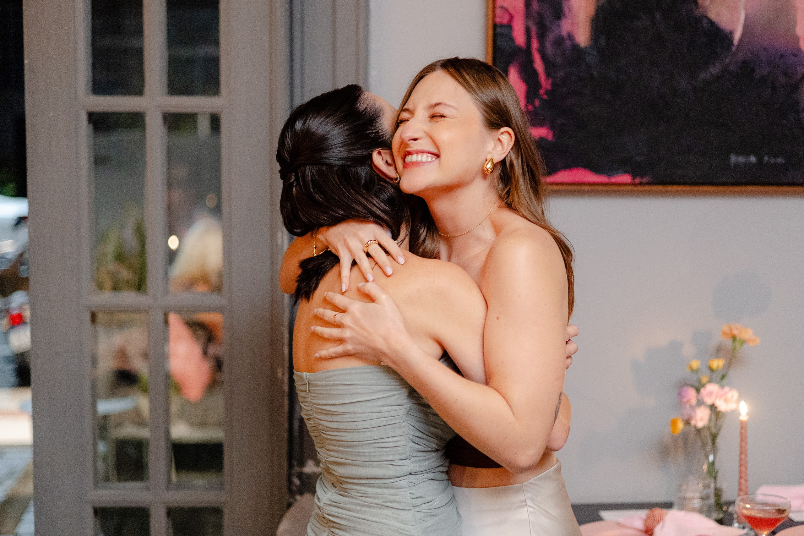 Fotógrafo de festa de formatura em Balneário Camboriú; formanda sorridente abraçando uma convidada emocionada.