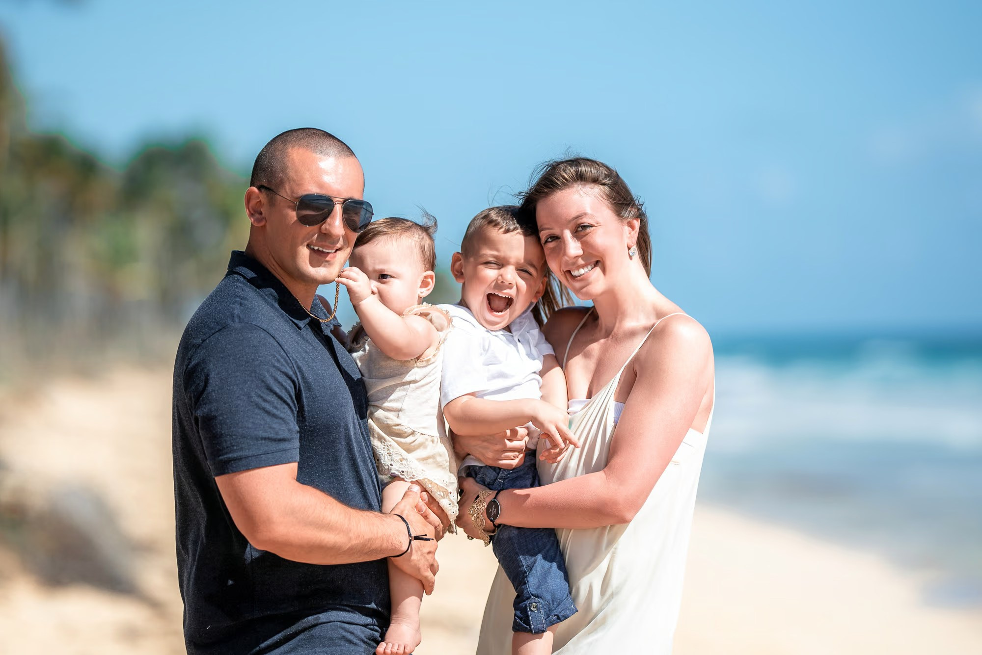 Retrato de uma família feliz durante um ensaio fotográfico profissional na Praia de Macao, República Dominicana.