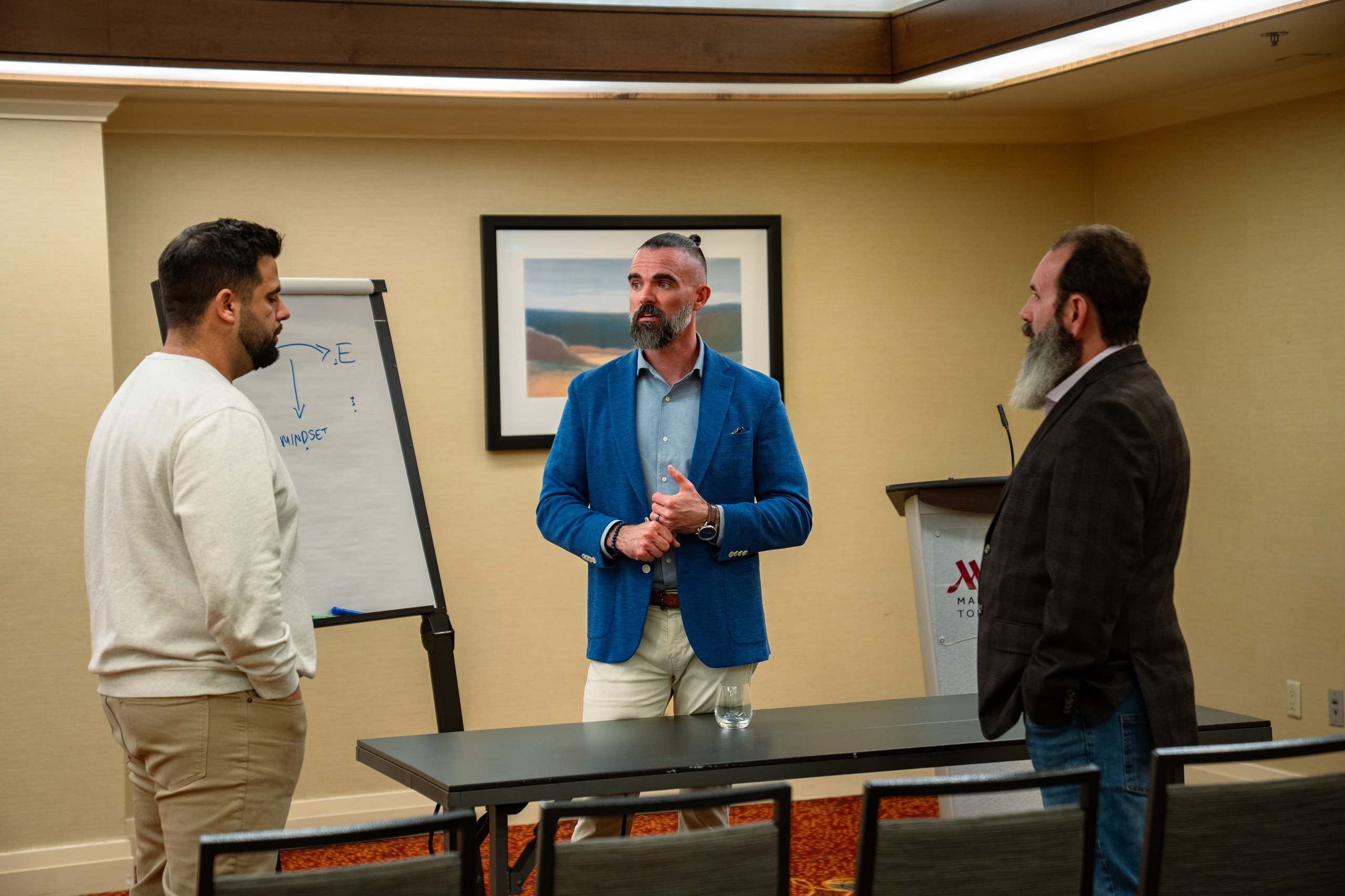 Matt Poechman speaking with two attendees at networking event