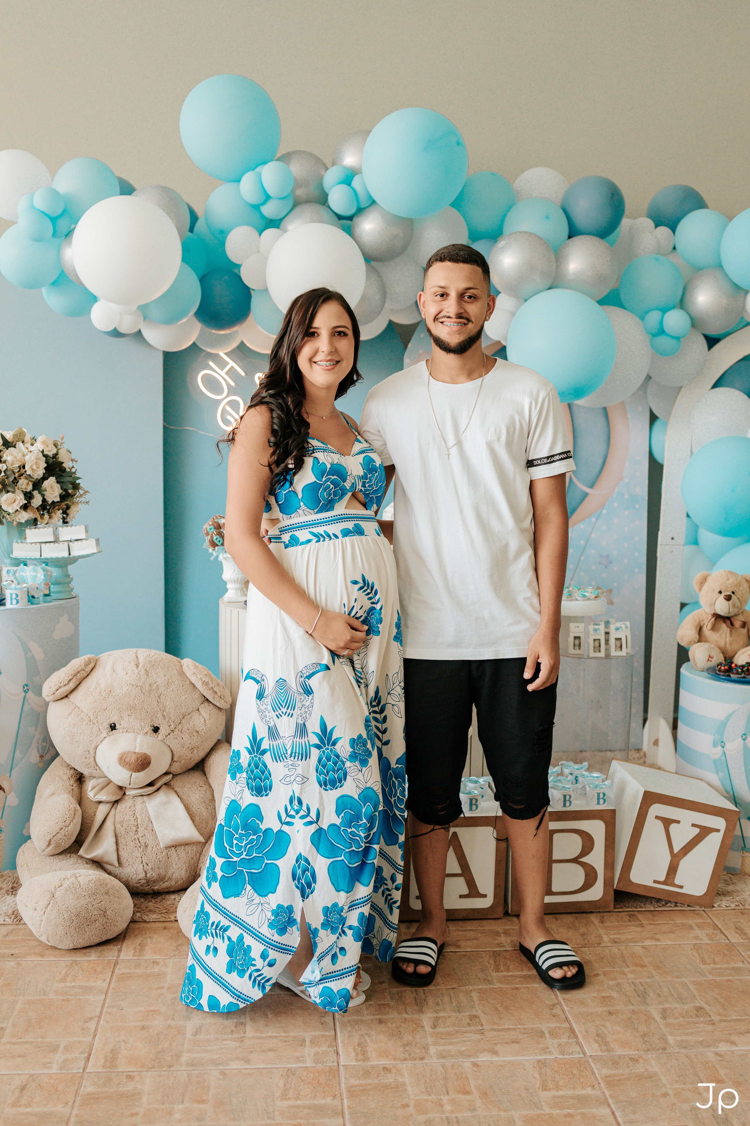 Casal de mãos dadas em frente à mesa do chá de bebê em Barra Bonita.