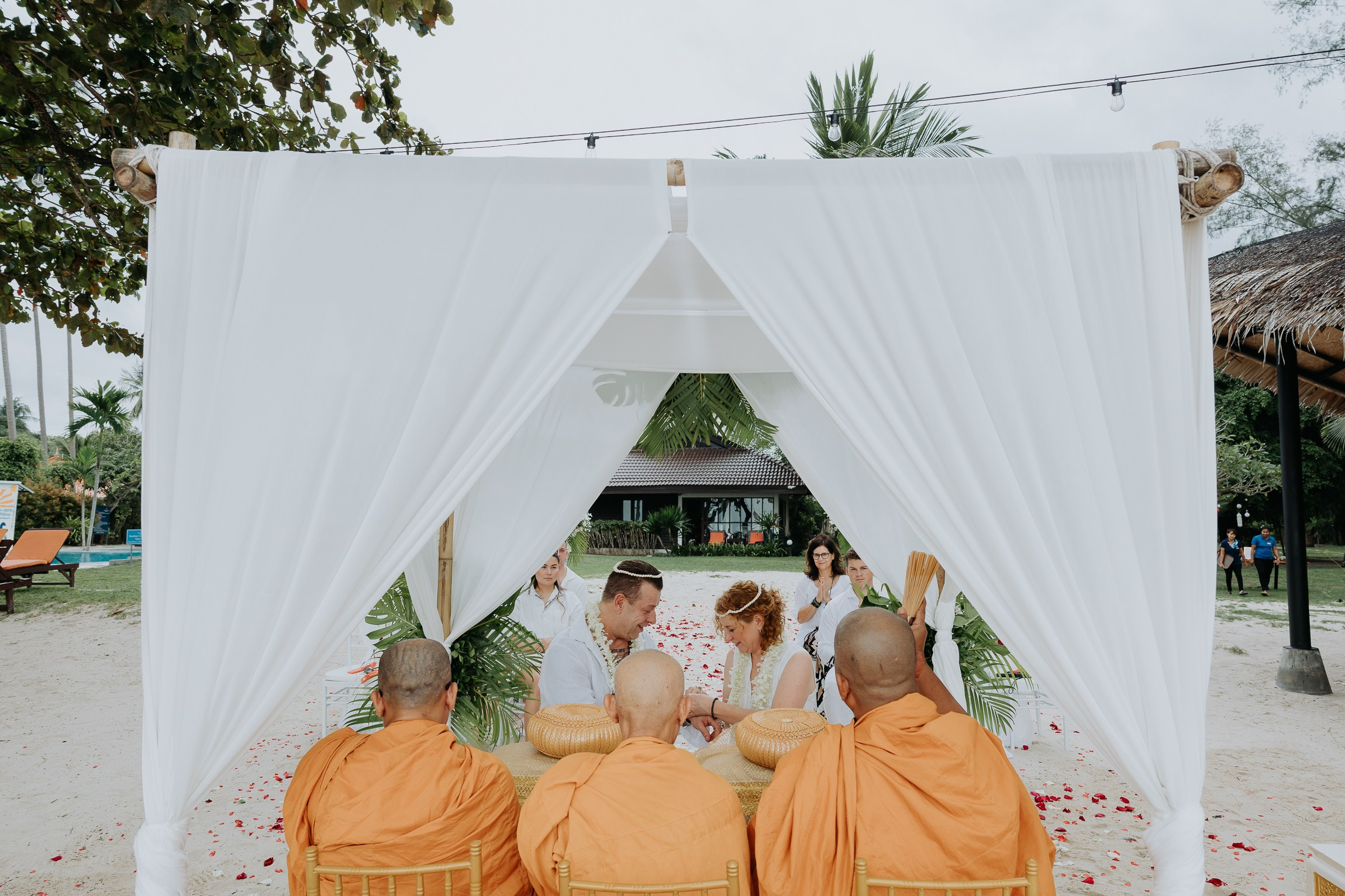 Couple with guests celebrating a spiritual Buddhist wedding ceremony on Koh Samui