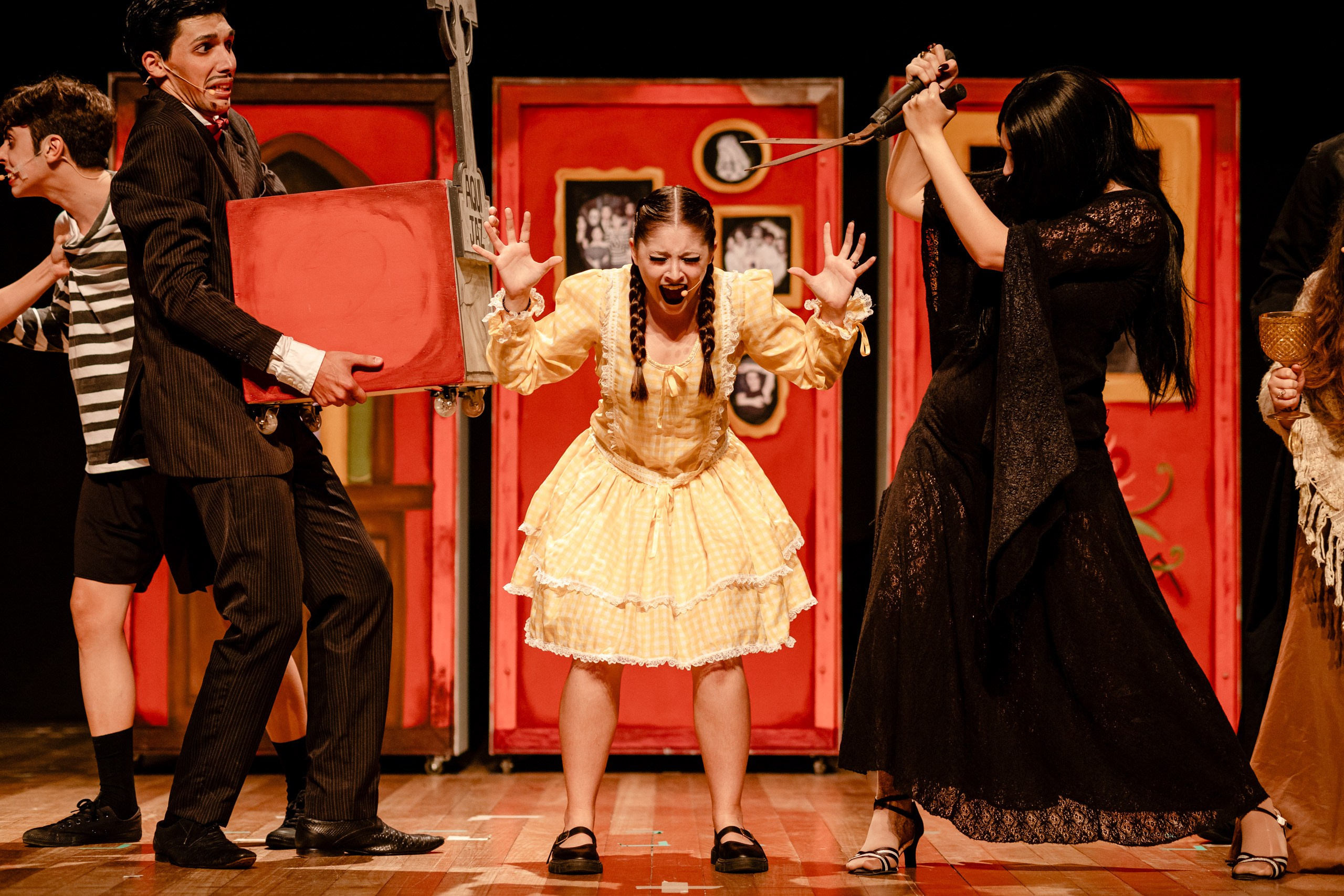 Apresentação teatral com a wandinha gritando em meio aos pais.