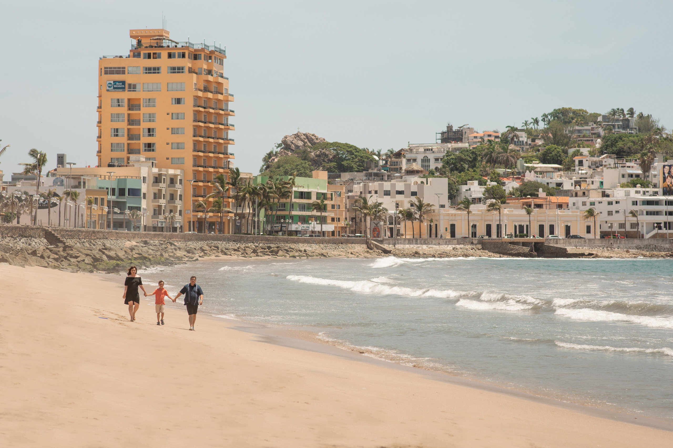 Tourist family  walk during their photoshoot on Mazatlan beach