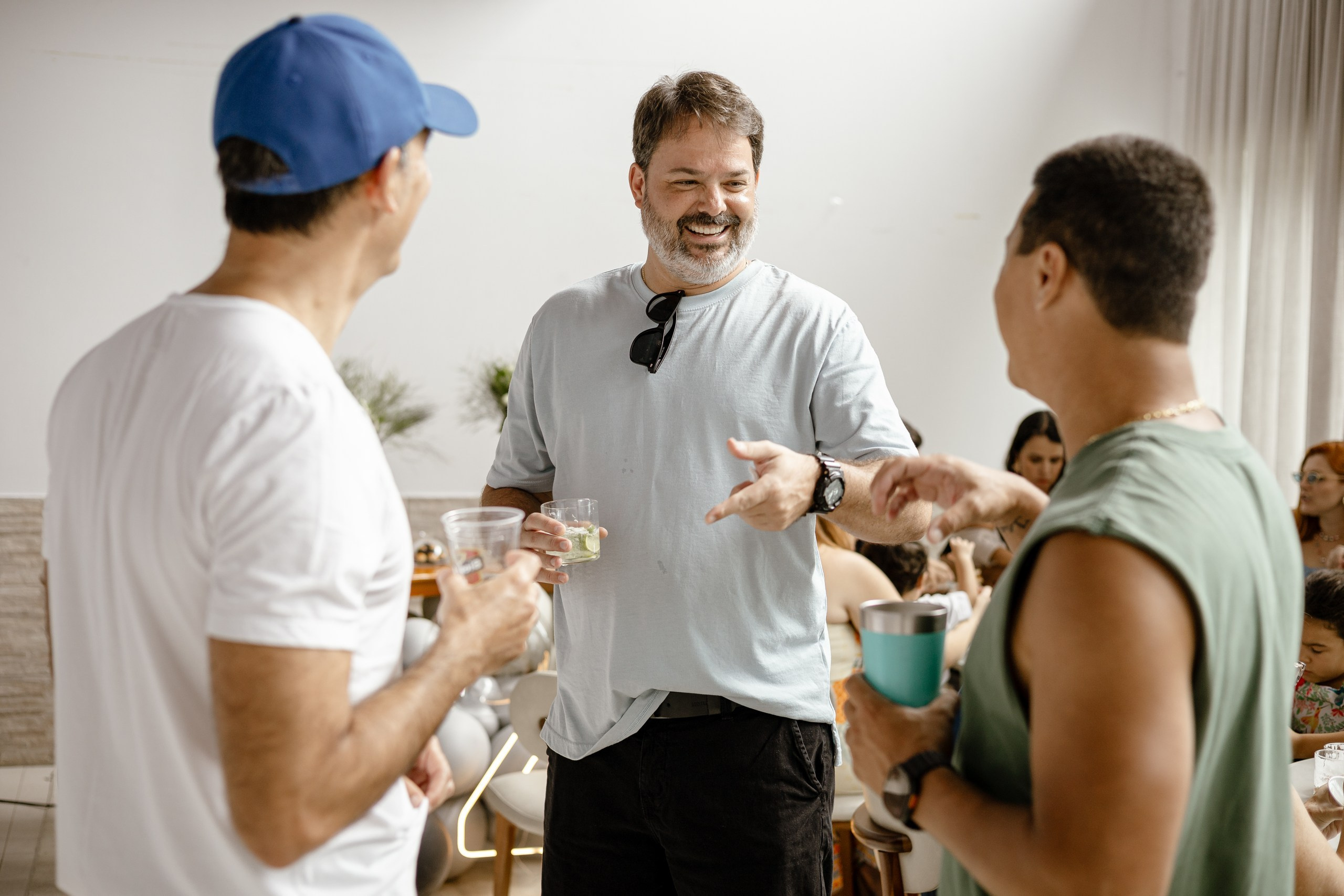 Fotografia de cobertura de festa e evento em Itajaí mostrando um grupo de convidados conversando de maneira descontraída e sorridente com copos nas mãos.
