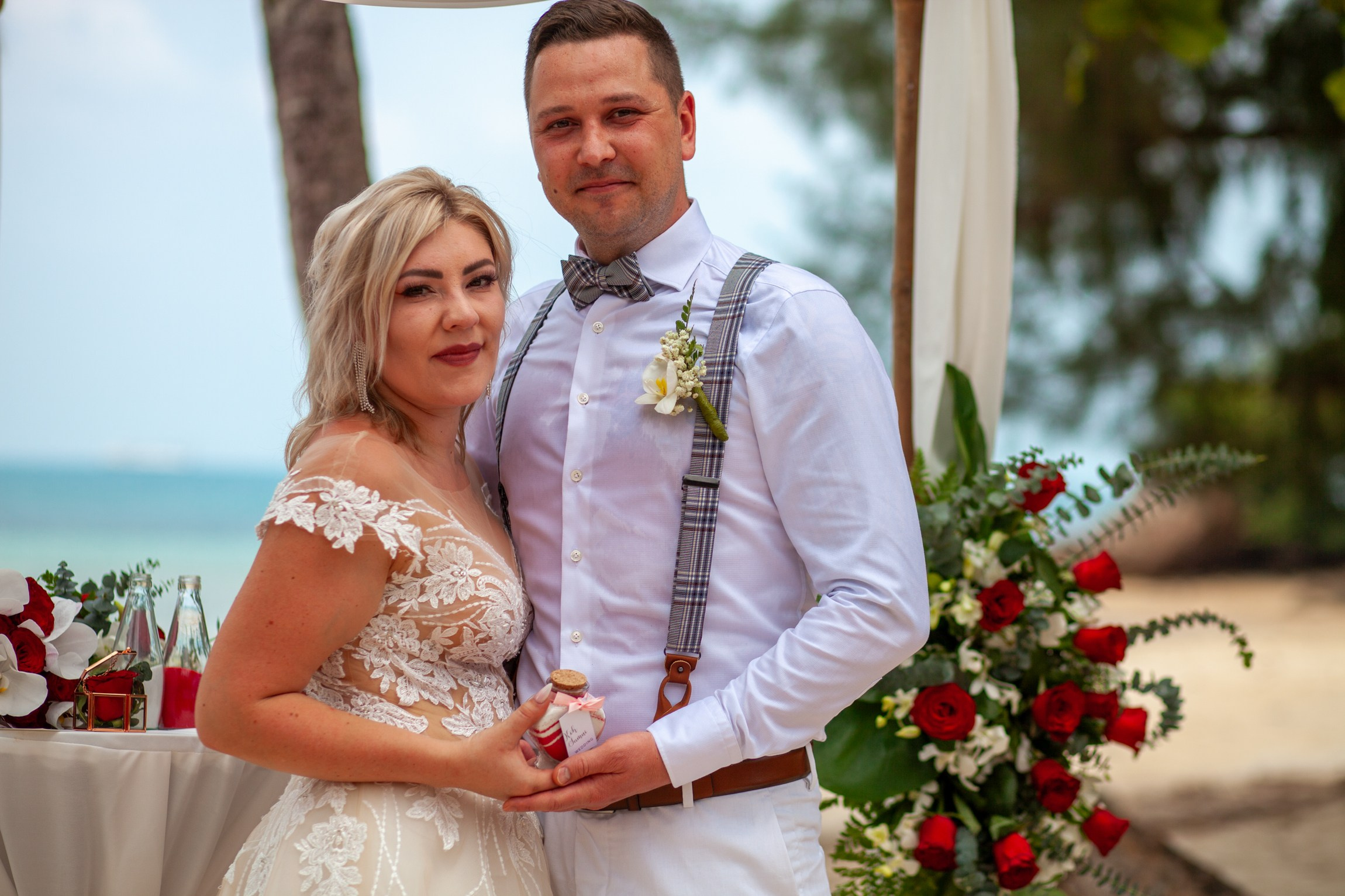 Elegant beach wedding setup on Koh Samui, Thailand with bride, groom, flowers and stunning sea backdrop