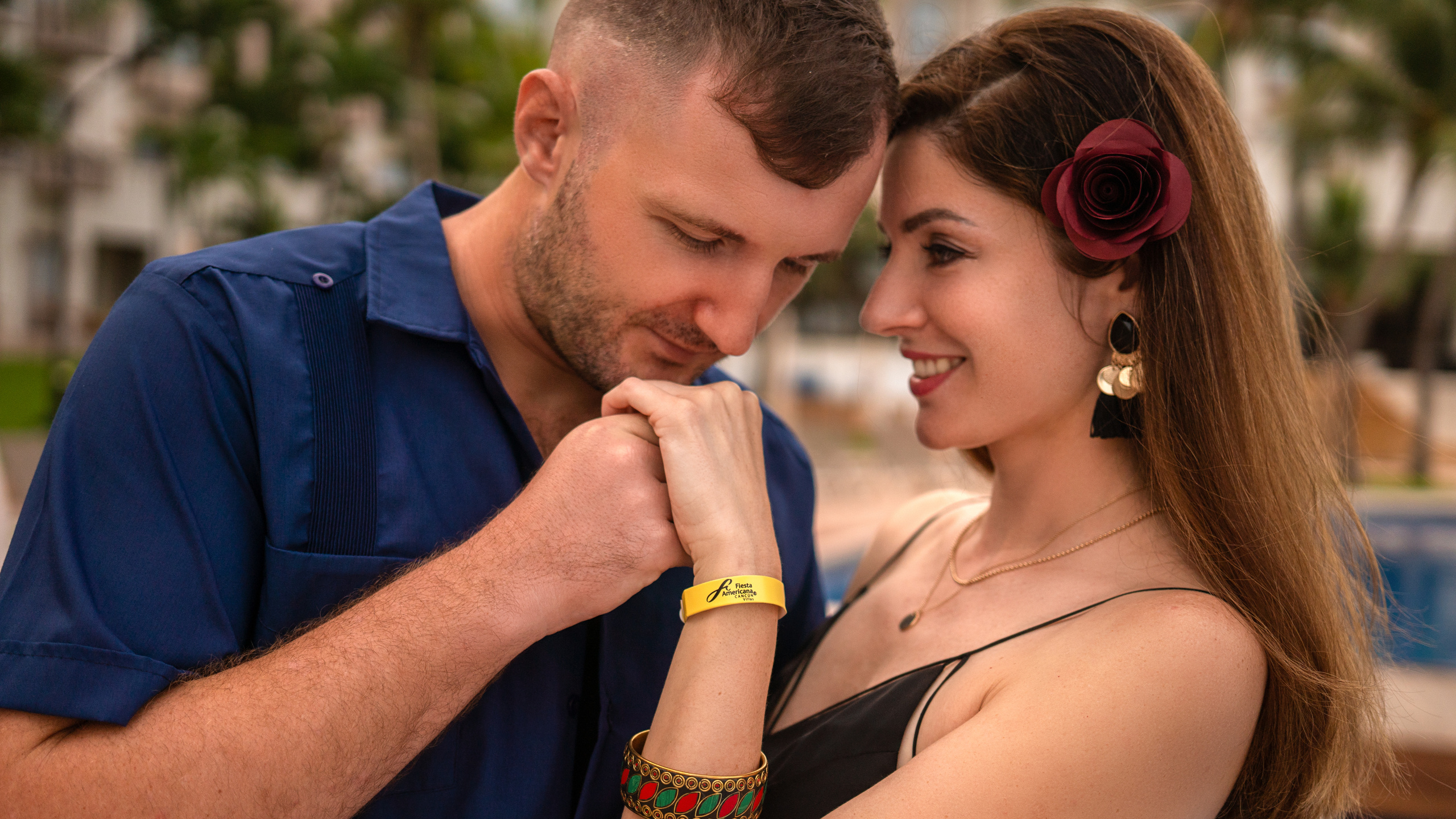 Romantic couple embracing in a luxury resort courtyard in Cancún, captured by a professional vacation photographer.