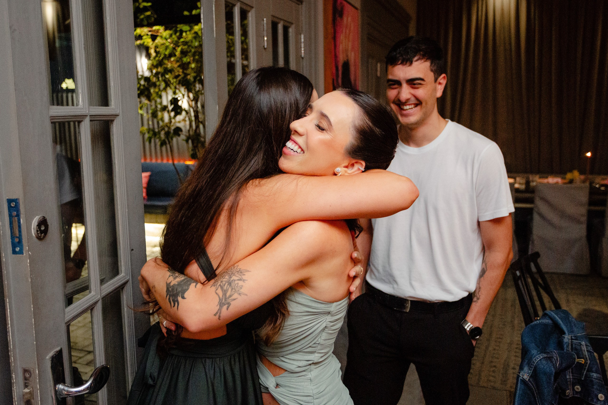 Fotógrafo de formatura em Balneário Camboriú; formanda sorridente abraçando uma convidada durante a recepção.