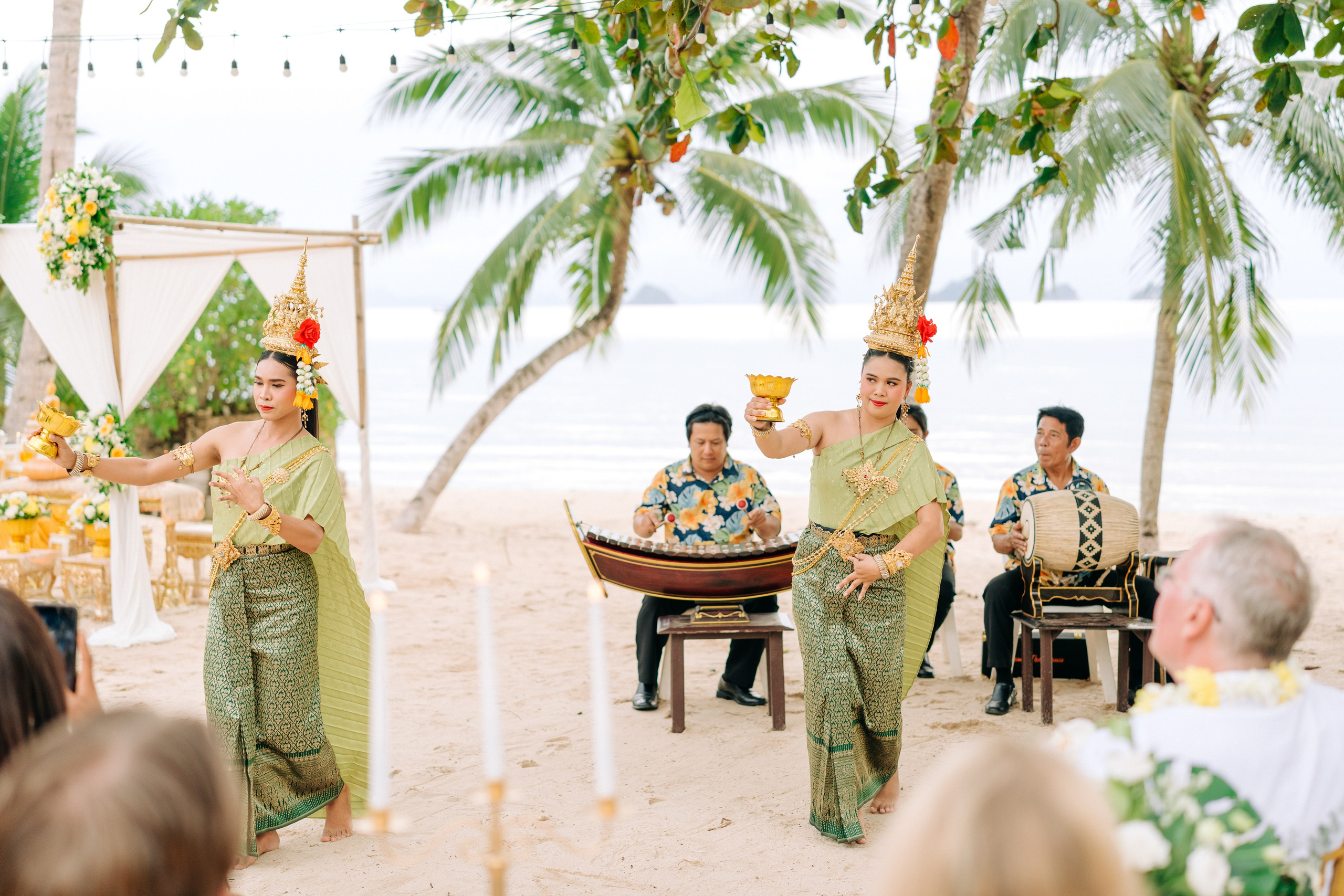 Bride and groom participating in a sacred Buddhist blessing ceremony by the sea in Koh Samui, Thailand.