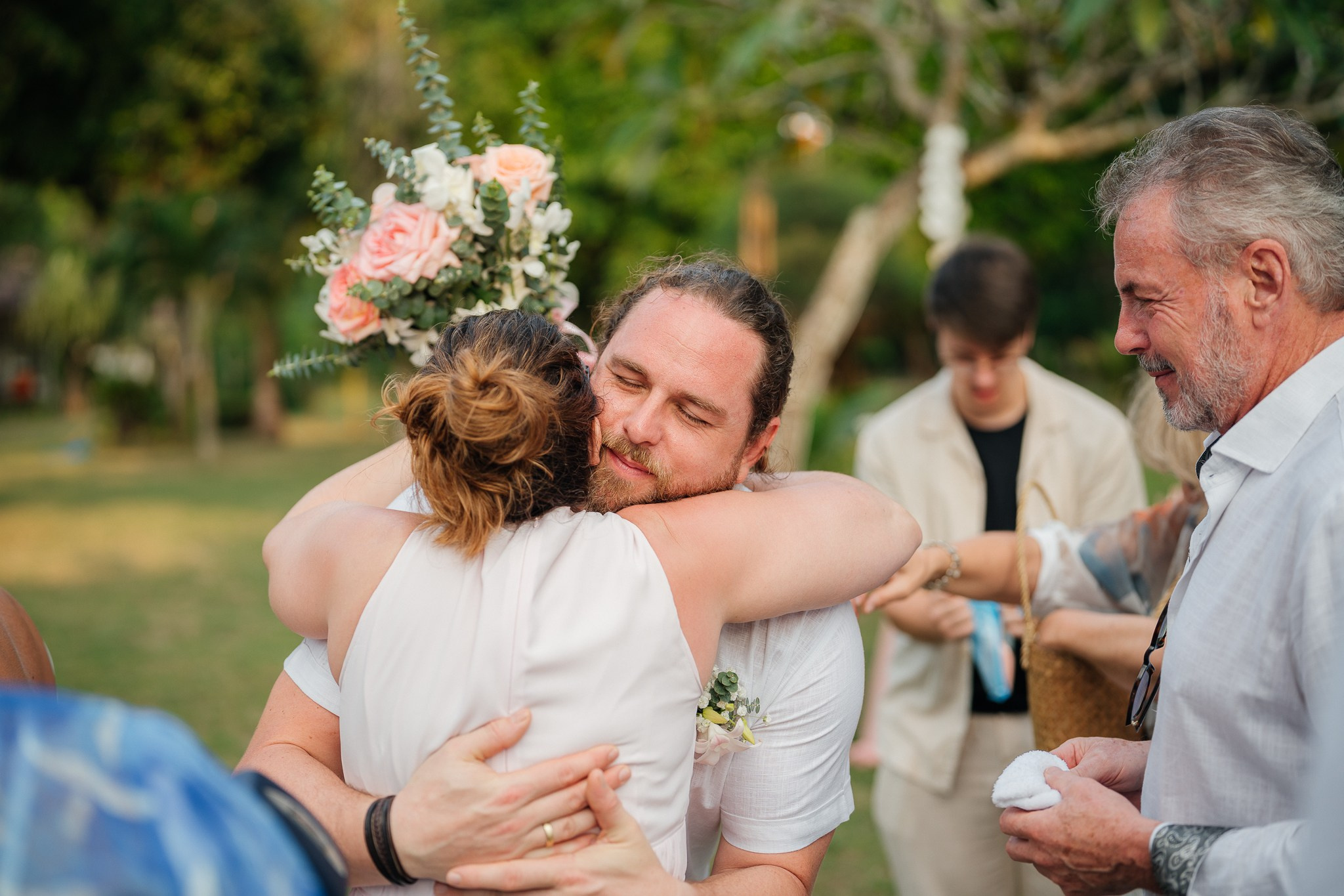 Destination beach wedding in Koh Samui, Thailand with the couple, family members and friends enjoying a tropical wedding ceremony by the sea