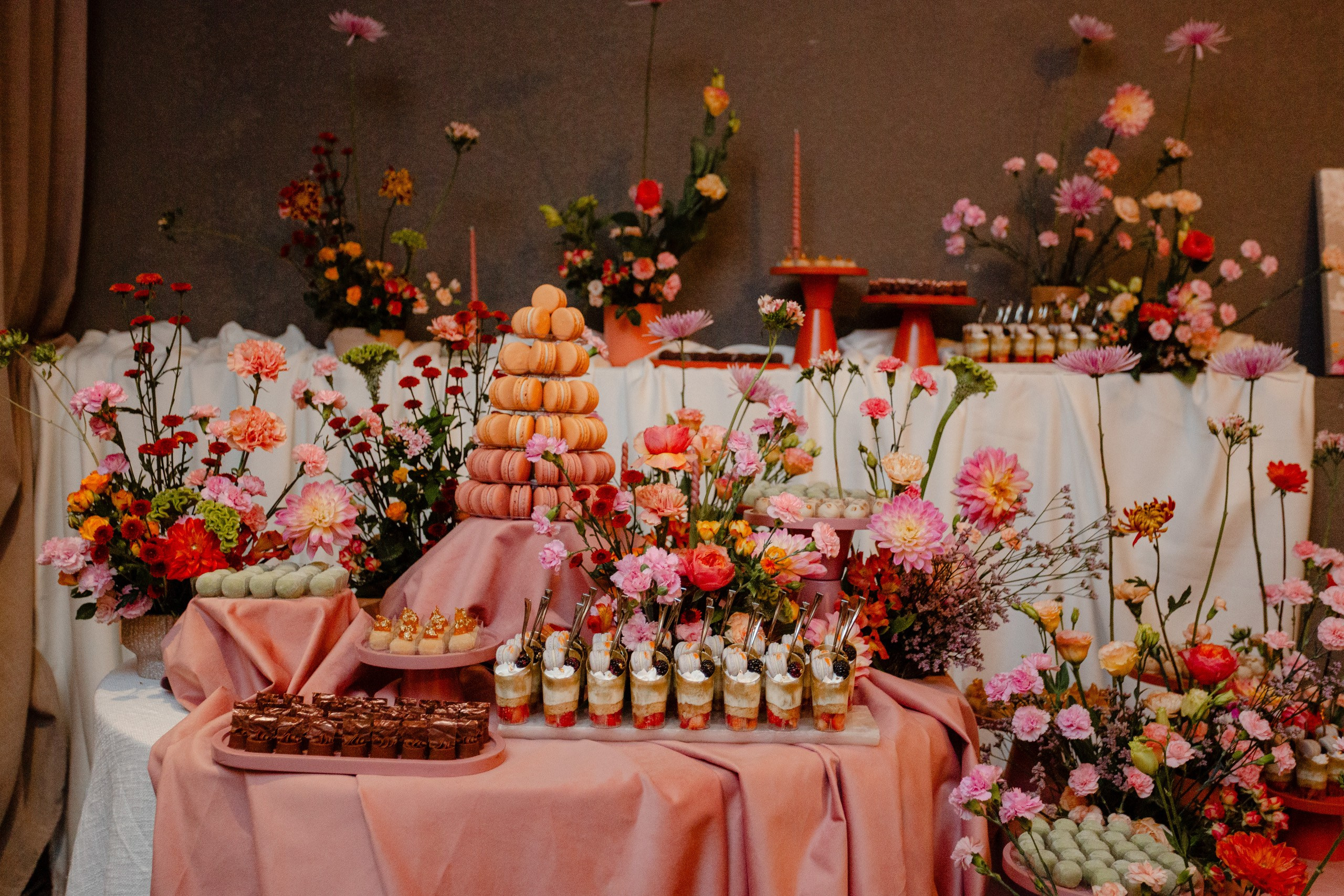 Mesa principal com arranjos florais exuberantes e doces finos em cobertura de festa de formatura em Balneário Camboriú.